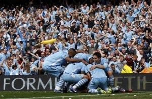 Manchester City's Pablo Zabaleta is mobbed by teammates after his goal during their English Premier League soccer match against Queens Park Rangers in Manchester