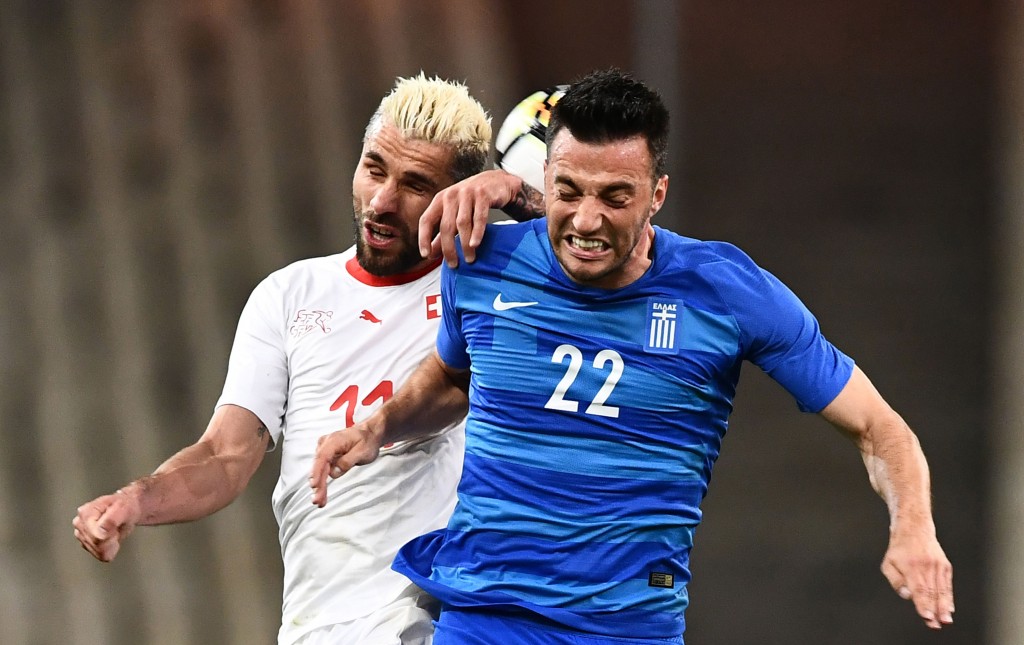 Greece's Andreas Samaris (R) fights for the ball with Switzerland's Valon Behrami during the international friendly football match between Greece and Switzerland in Athens on March 23, 2018. (Photo courtesy - Aris Messinis/AFP/Getty Images)