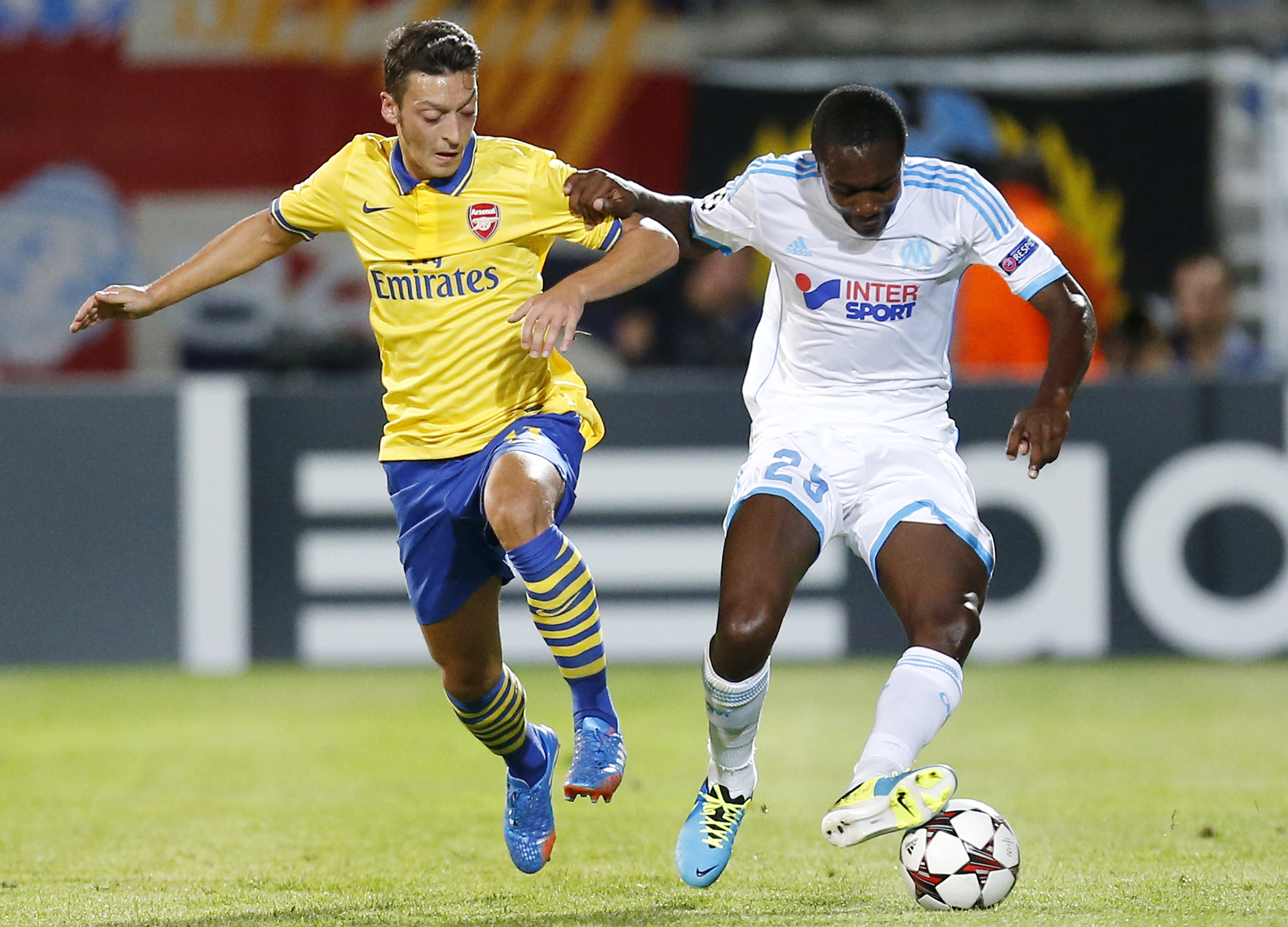 epa03873078 Olympique Marseille's Giannelli Imbula (R) vies for the ball with Arsenal's Mesut Oezil (L) during the UEFA Champions League match between Olympique Marseille and Arsenal at the Velodrome Stadium in Marseille, France, 18 September 2013.  EPA/GUILLAUME HORCAJUELO