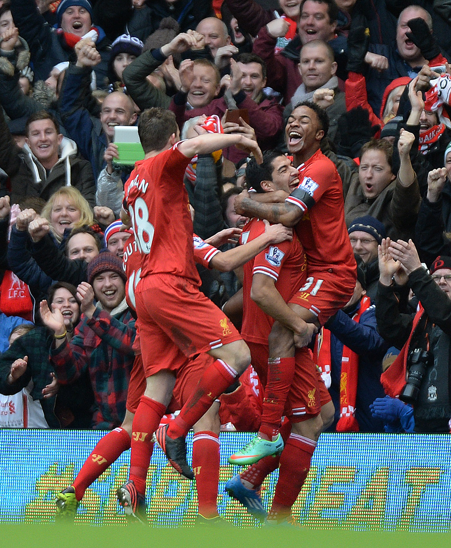 epa04061491 Liverpool's Raheem Sterling (R) is lifted in the air by team-mate Luis Suarez (C) in celebration after scoring the 3-0 goal during the English Premier League soccer match between Liverpool FC and Arsenal FC at Anfield Road stadium in Liverpool, Britain, 08 February 2014.  EPA/PETER POWELL DataCo terms and conditions apply http://www.epa.eu/files/Terms%20and%20Conditions/DataCo_Terms_and_Conditions.pdf