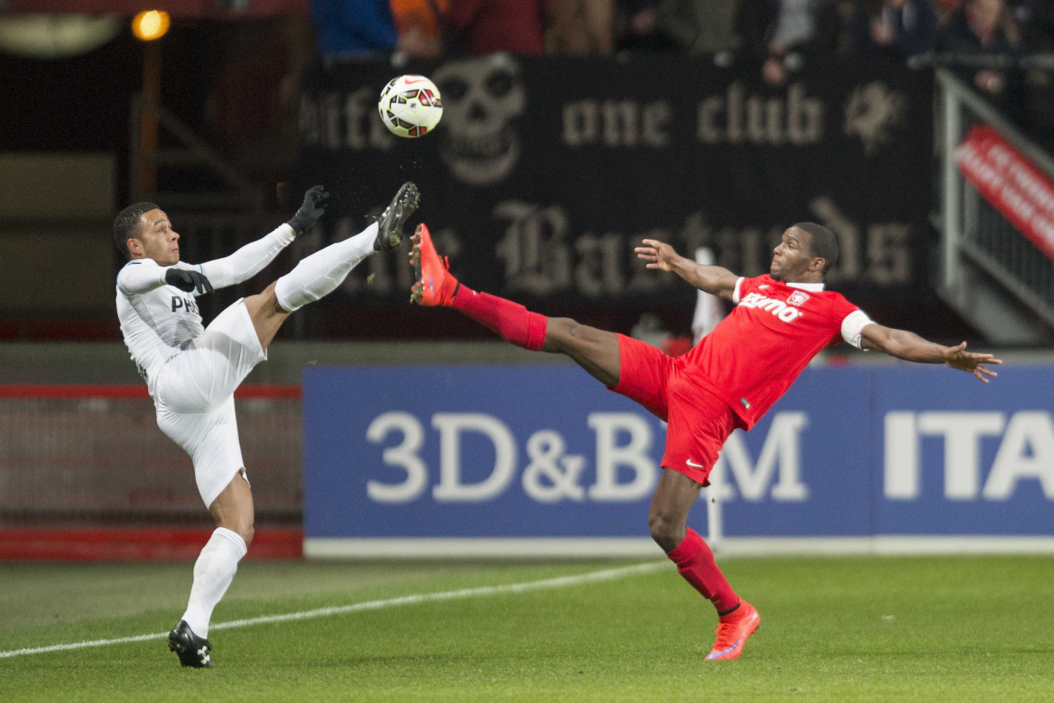 epa04692428 Eindhoven PSV player Memphis Depay (L) in action against FC Twente Cuco Martina (R) during the Dutch Eredivisie soccer match between PSV Eindhoven and FC Twente Enschede in Enschede, Netherlands, 04 April 2015.  EPA/Jasper Ruhe