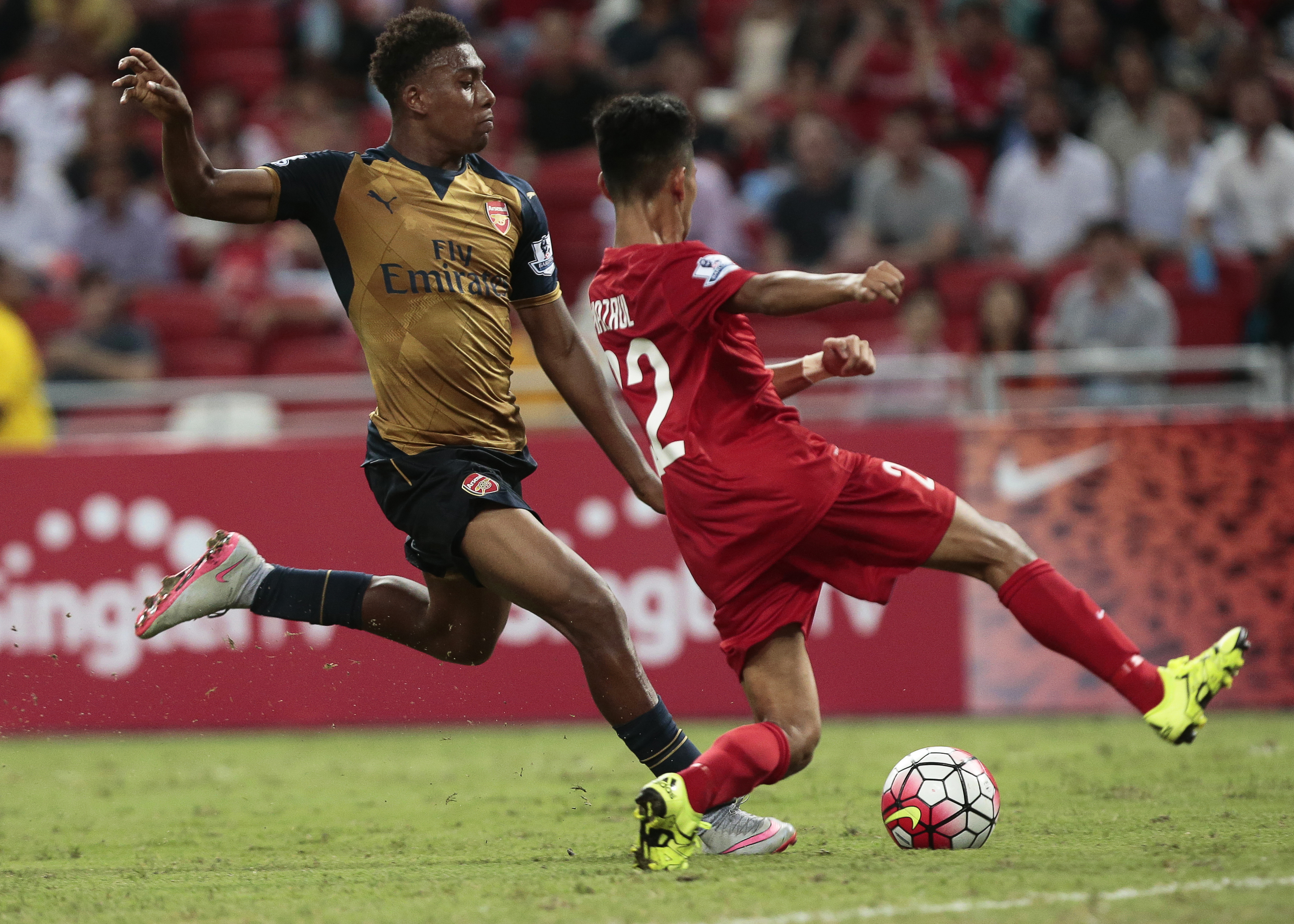 epa04847841 Arsenal's Alex Iwobi (L) in action against Singapore Selection's Nazrul Nazari (R) during the Barclays Asia Trophy soccer match between Arsenal FC and a Singapore Selection at the National Stadium in Singapore, 15 July 2015. The Barclays Asia Trophy takes place on 15 and 18 July 2015 involving English Premier League teams Arsenal, Everton, and Stoke City and a Singapore Selection team.  EPA/WALLACE WOON