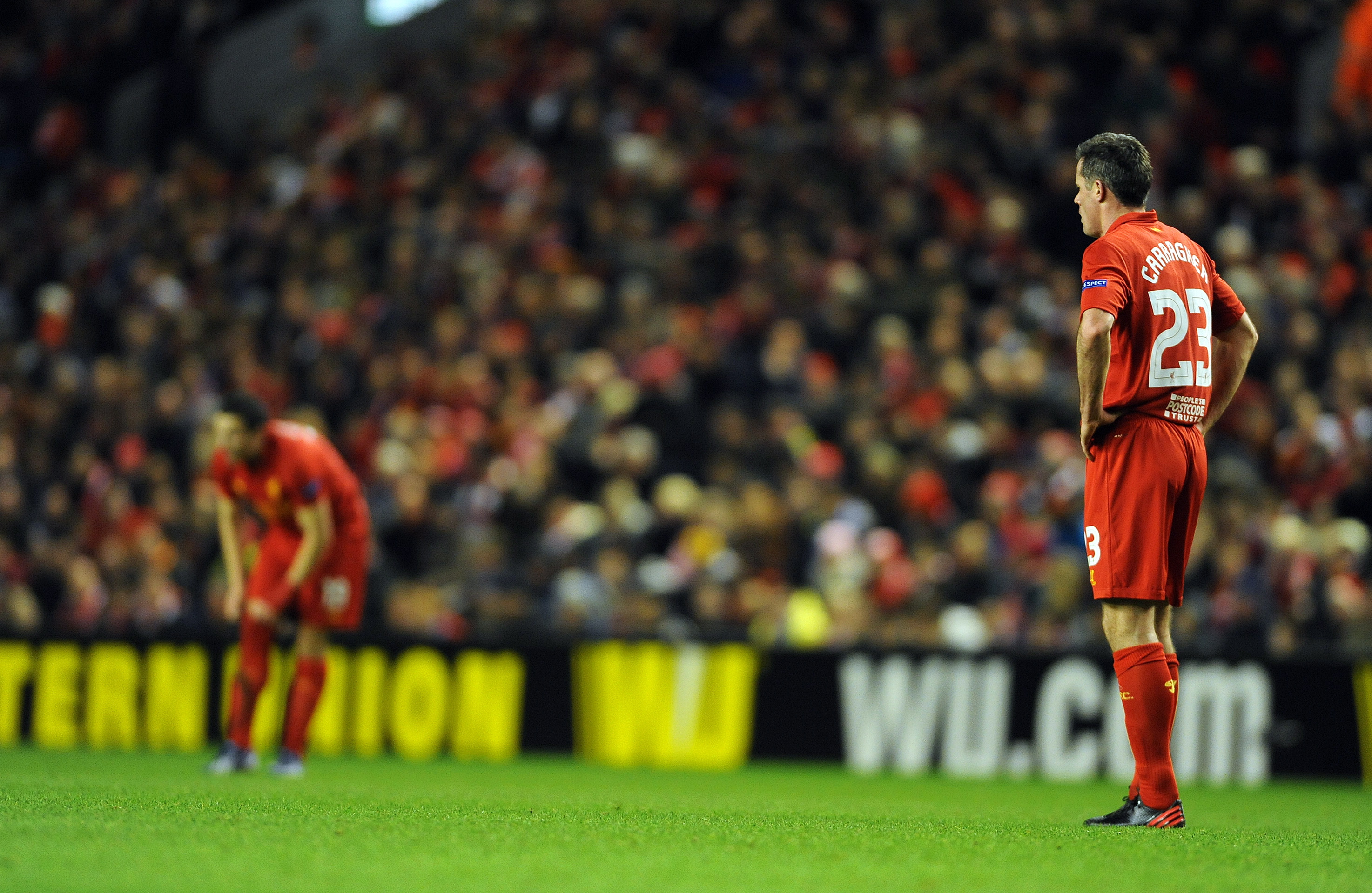 epa03594538 Liverpool's Jamie Carragher (R) shows his dejection during the UEFA Europa League round of 32 second leg soccer match against Zenit St.Petersburg at Anfield in Liverpool, Britain, 21 February 2013.  EPA/PETER POWELL