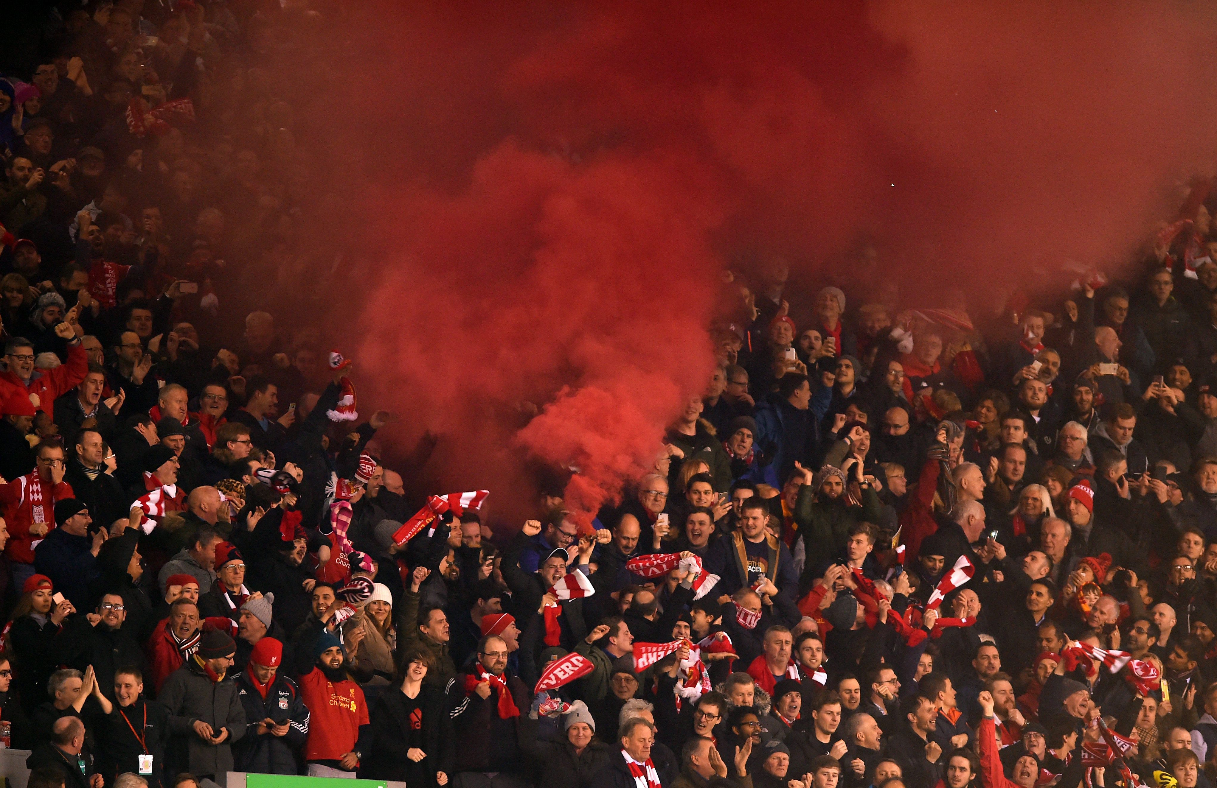 epa05205273 Red smoke rises from the main stand after Liverpool scored the 2-0 during the UEFA Europa League round of 16 soccer match between Liverpool and Manchester United at Anfield in Liverpool, Britain, 10 March 2016.  EPA/PETER POWELL
