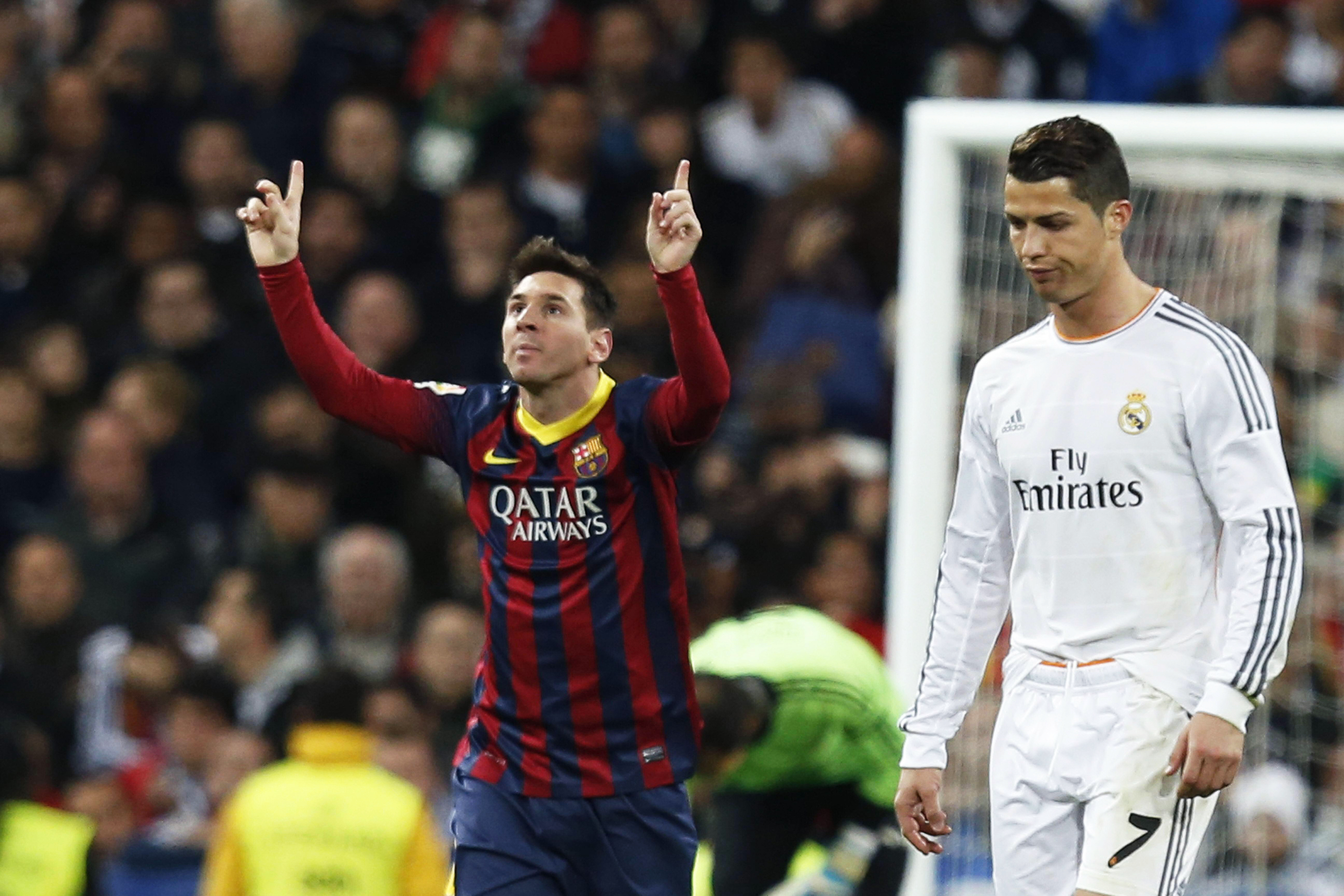 epa04138223 FC Barcelona's Argentinian striker Lionel Messi (L) celebrates after scoring the 3-3 equalizer from the penalty spot next to Real Madrid's Portuguese Cristiano Ronaldo (R) during the Spanish Primera Division soccer match between Real Madrid and FC Barcelona, traditionally known as 'El Clasico', at Santiago Bernabeu stadium in Madrid, Spain, 23 March 2014.  EPA/JAVIER LIZON