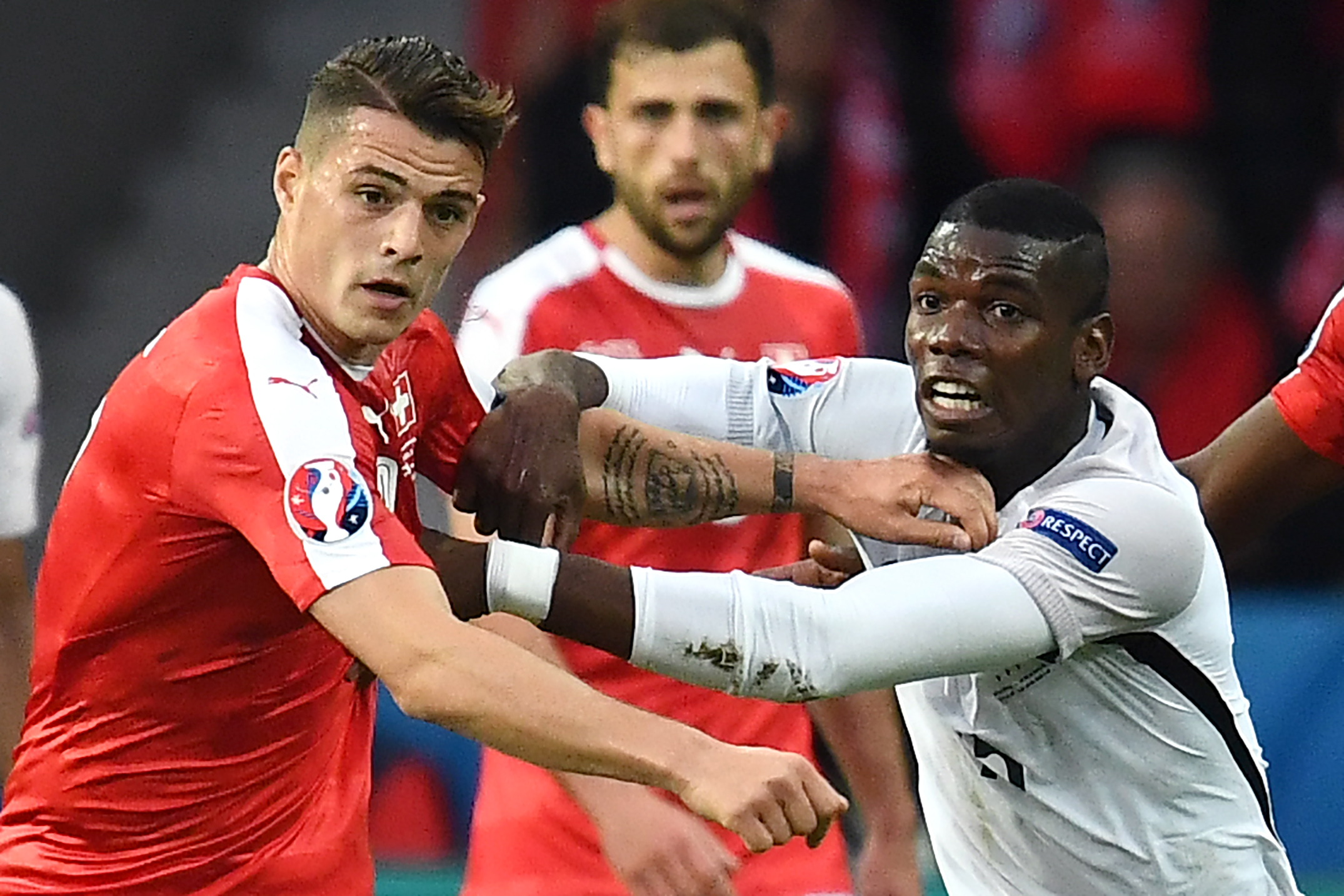 Switzerland's midfielder Granit Xhaka (L) vies for the ball against France's midfielder Paul Pogba during the Euro 2016 group A football match between Switzerland and France at the Pierre-Mauroy stadium in Lille on June 19, 2016. / AFP / FRANCK FIFE        (Photo credit should read FRANCK FIFE/AFP/Getty Images)