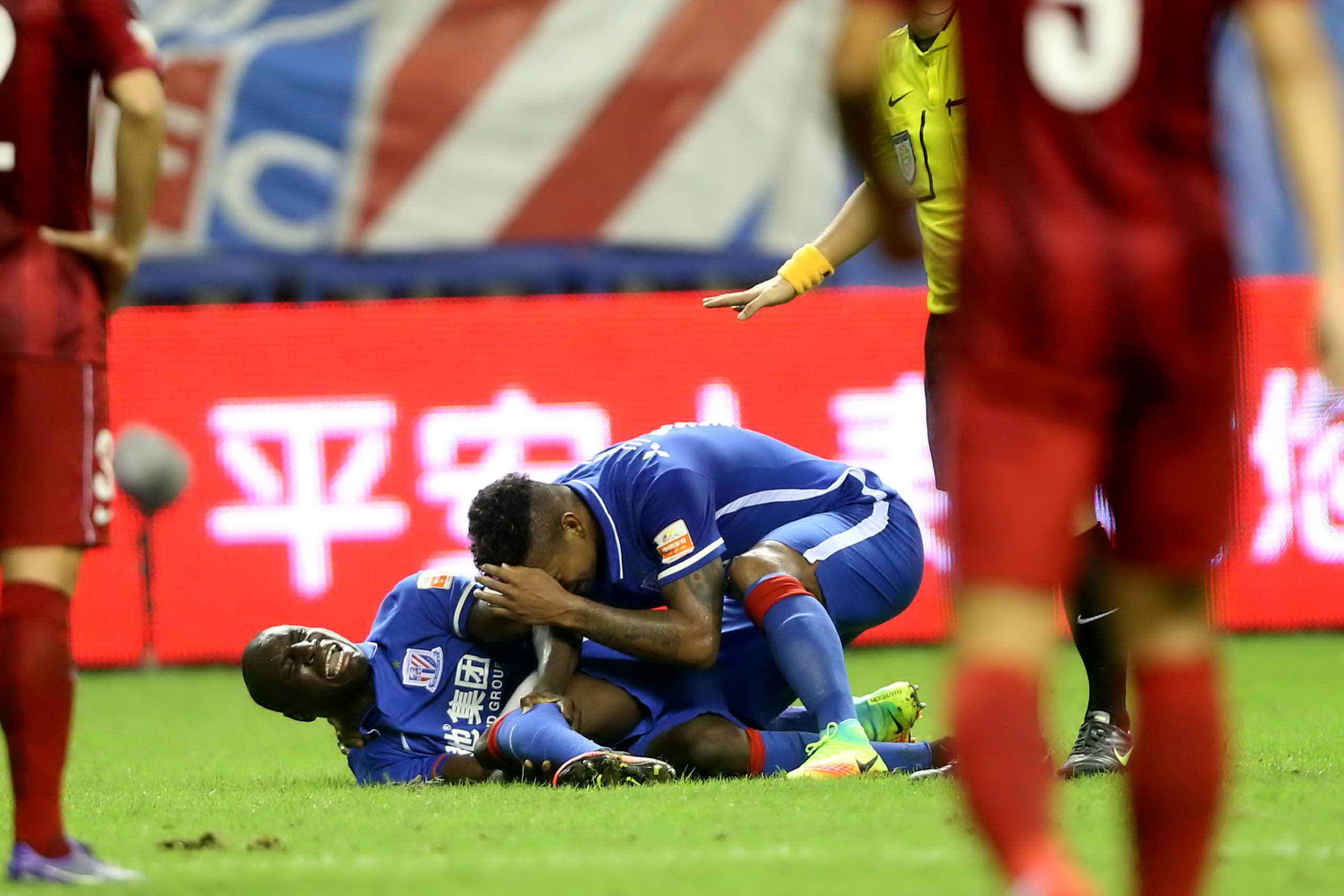 This photo taken on July 17, 2016 shows Demba Ba (L) of Shanghai Shenhua reacting after breaking his left leg during the 17th round football match of the Chinese Super League against Shanghai SIPG in Shanghai. 
Former Chelsea striker Demba Ba suffered a horror broken leg in the Shanghai derby at the weekend, with his coach warning the injury could end the 31-year-old's playing career. / AFP / STR / China OUT        (Photo credit should read STR/AFP/Getty Images)