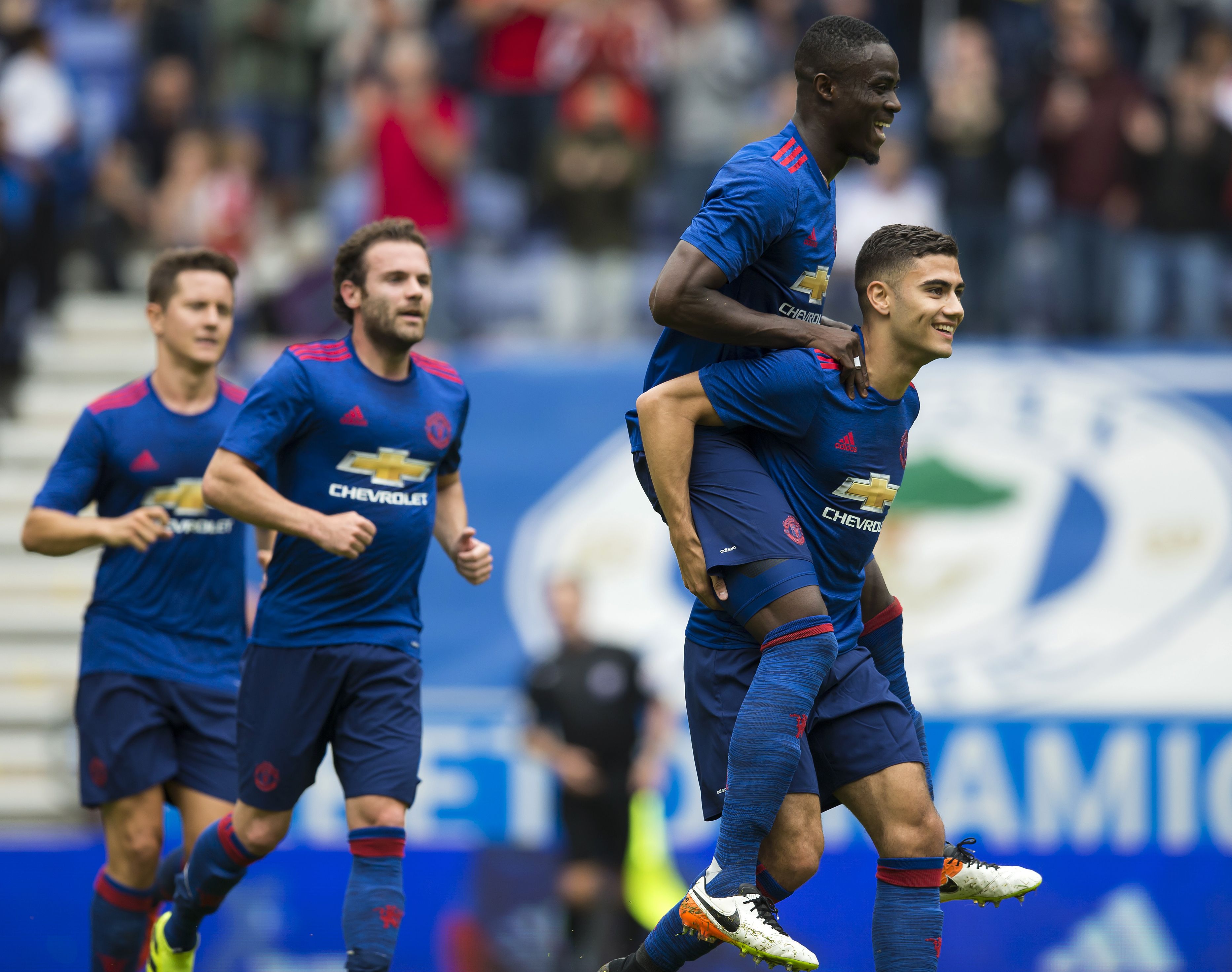 Manchester United's Belgian midfielder Andreas Pereira (R) celebrates with Manchester United's Ivorian midfielder Eric Bailly (2R) after scoring during the pre-season friendly football match between Wigan Athletic and Manchester United at the DW stadium in Wigan, northwest England, on July 16, 2016.  / AFP / JON SUPER / RESTRICTED TO EDITORIAL USE. No use with unauthorized audio, video, data, fixture lists, club/league logos or 'live' services. Online in-match use limited to 75 images, no video emulation. No use in betting, games or single club/league/player publications.  /         (Photo credit should read JON SUPER/AFP/Getty Images)