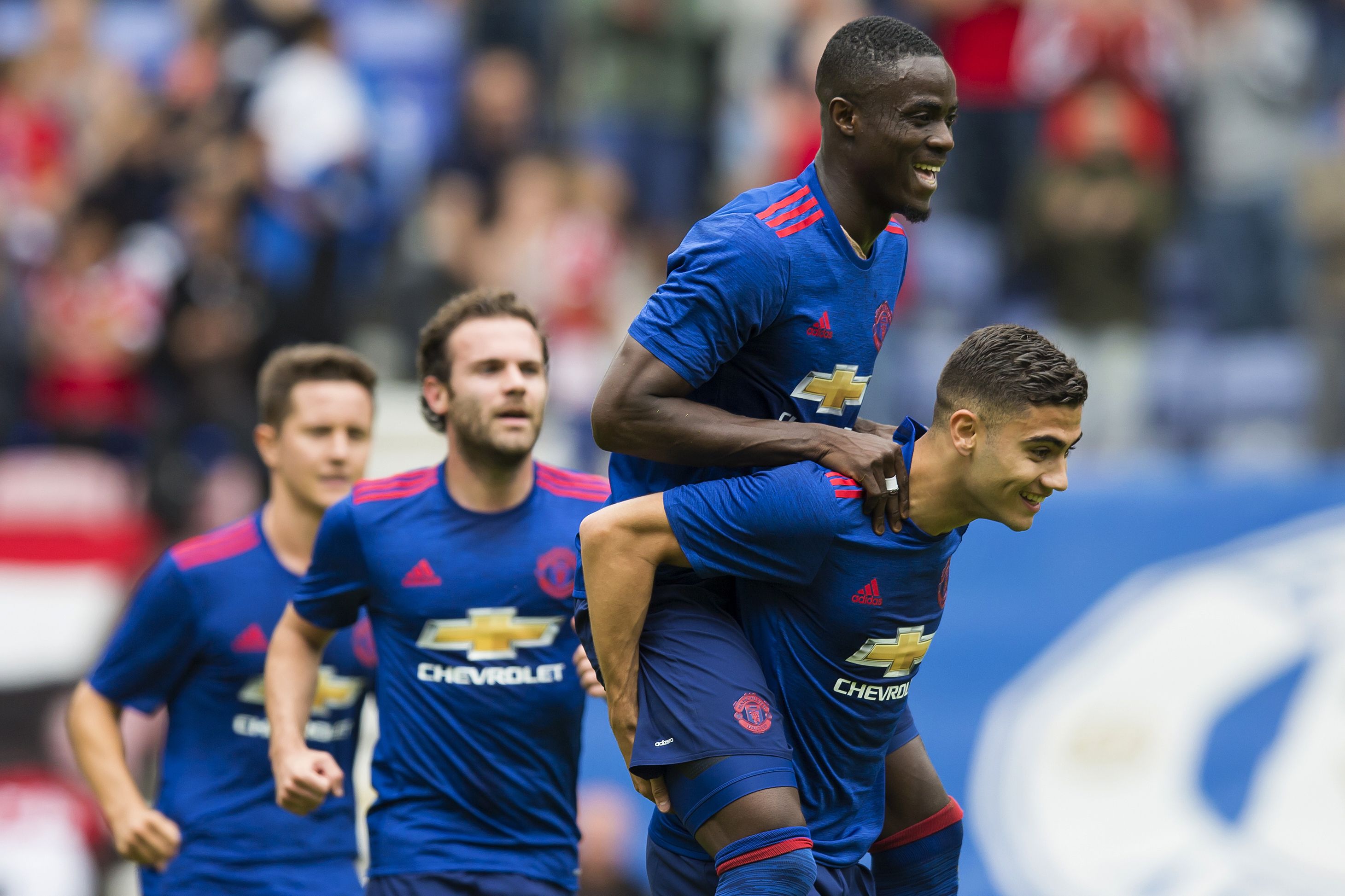 Manchester United's Belgian midfielder Andreas Pereira (R) celebrates with Manchester United's Ivorian midfielder Eric Bailly (2R) and Manchester United's Spanish midfielder Juan Mata (2L) after scoring during the pre-season friendly football match between Wigan Athletic and Manchester United at the DW stadium in Wigan, northwest England, on July 16, 2016.  / AFP / JON SUPER / RESTRICTED TO EDITORIAL USE. No use with unauthorized audio, video, data, fixture lists, club/league logos or 'live' services. Online in-match use limited to 75 images, no video emulation. No use in betting, games or single club/league/player publications.  /         (Photo credit should read JON SUPER/AFP/Getty Images)