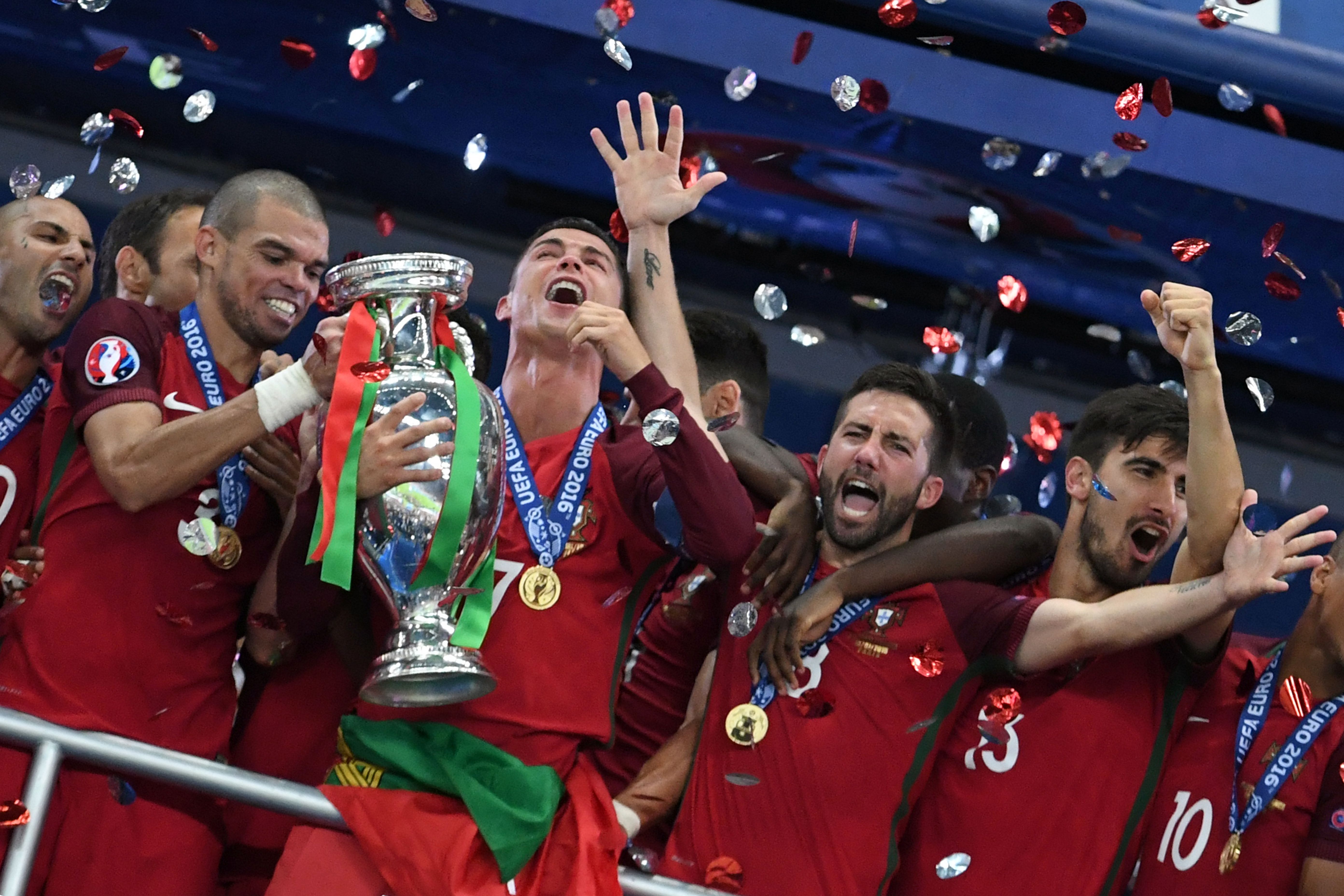 Portugal's forward Cristiano Ronaldo (3rdL) lifts the trophy as he celebrates with teammates (fromL) Portugal's forward Ricardo Quaresma, Portugal's defender Pepe, Portugal's midfielder Joao Moutinho and Portugal's midfielder Andre Gomes after they won the Euro 2016 final football match between Portugal and France at the Stade de France in Saint-Denis, north of Paris, on July 10, 2016. / AFP / FRANCISCO LEONG        (Photo credit should read FRANCISCO LEONG/AFP/Getty Images)