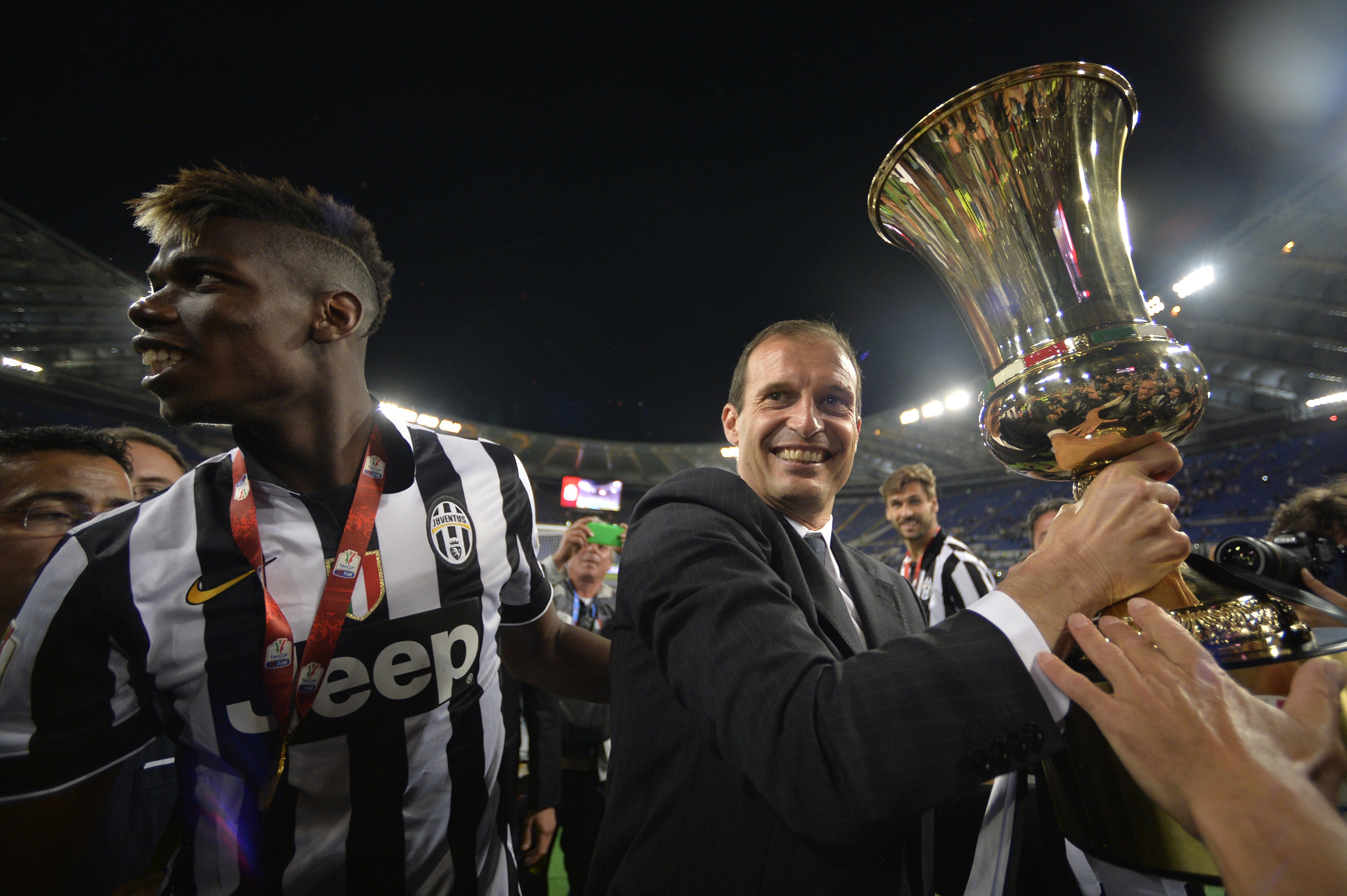 Juventus' coach Massimiliano Allegri (R) and Juventus' midfielder from France Paul Pogba celebrate with the trophy after winning 2-1 the Italian Tim Cup final match (Coppa Italia) between Juventus and Lazio on May 20, 2015 at the Stadio Olimpico in Rome.       AFP PHOTO / ANDREAS SOLARO        (Photo credit should read ANDREAS SOLARO/AFP/Getty Images)