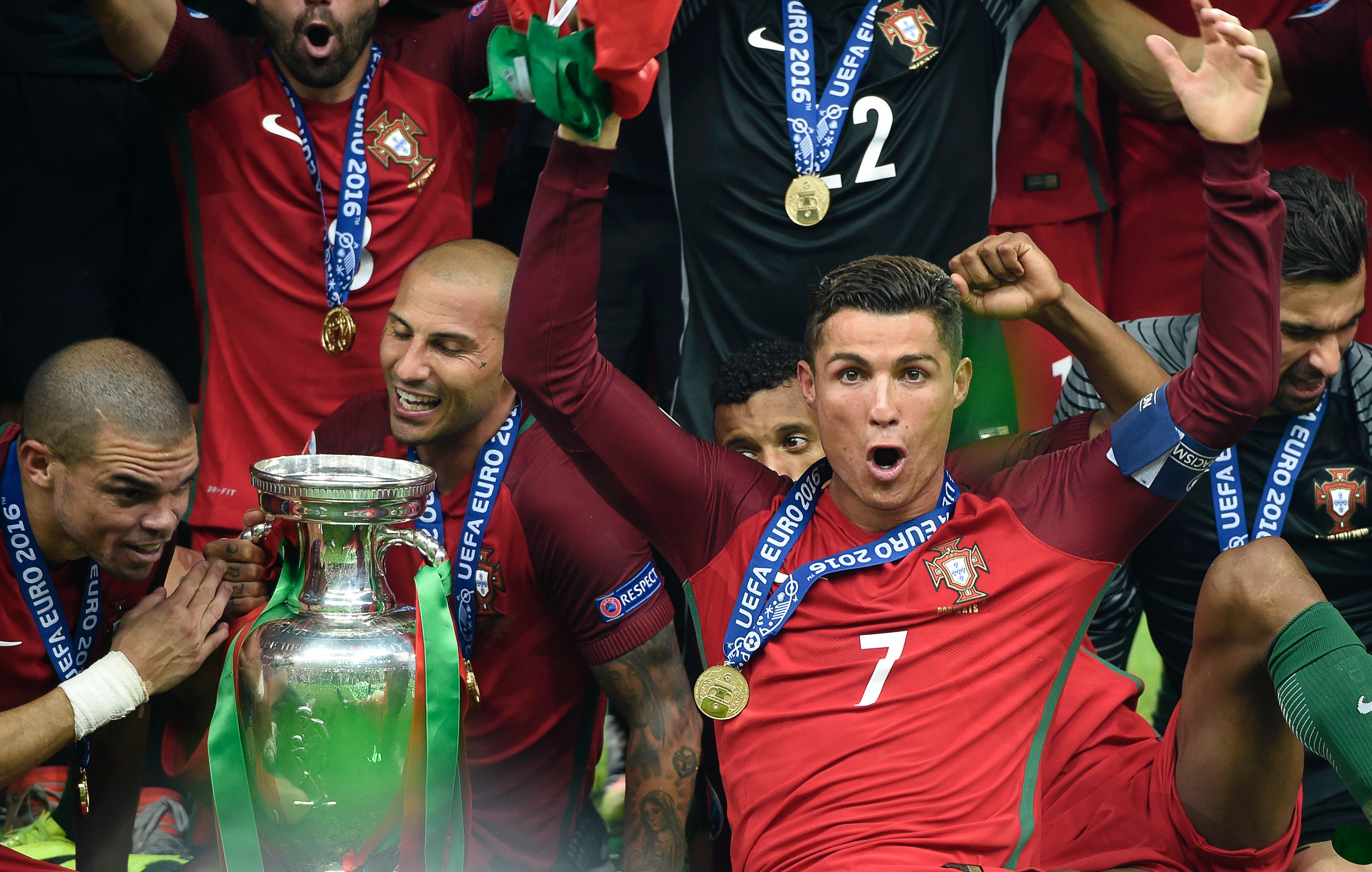 (From L) Portugal's defender Pepe, Portugal's forward Ricardo Quaresma and Portugal's forward Cristiano Ronaldo pose with the trophy as they celebrate after beating France during the Euro 2016 final football match at the Stade de France in Saint-Denis, north of Paris, on July 10, 2016. / AFP / PHILIPPE DESMAZES        (Photo credit should read PHILIPPE DESMAZES/AFP/Getty Images)