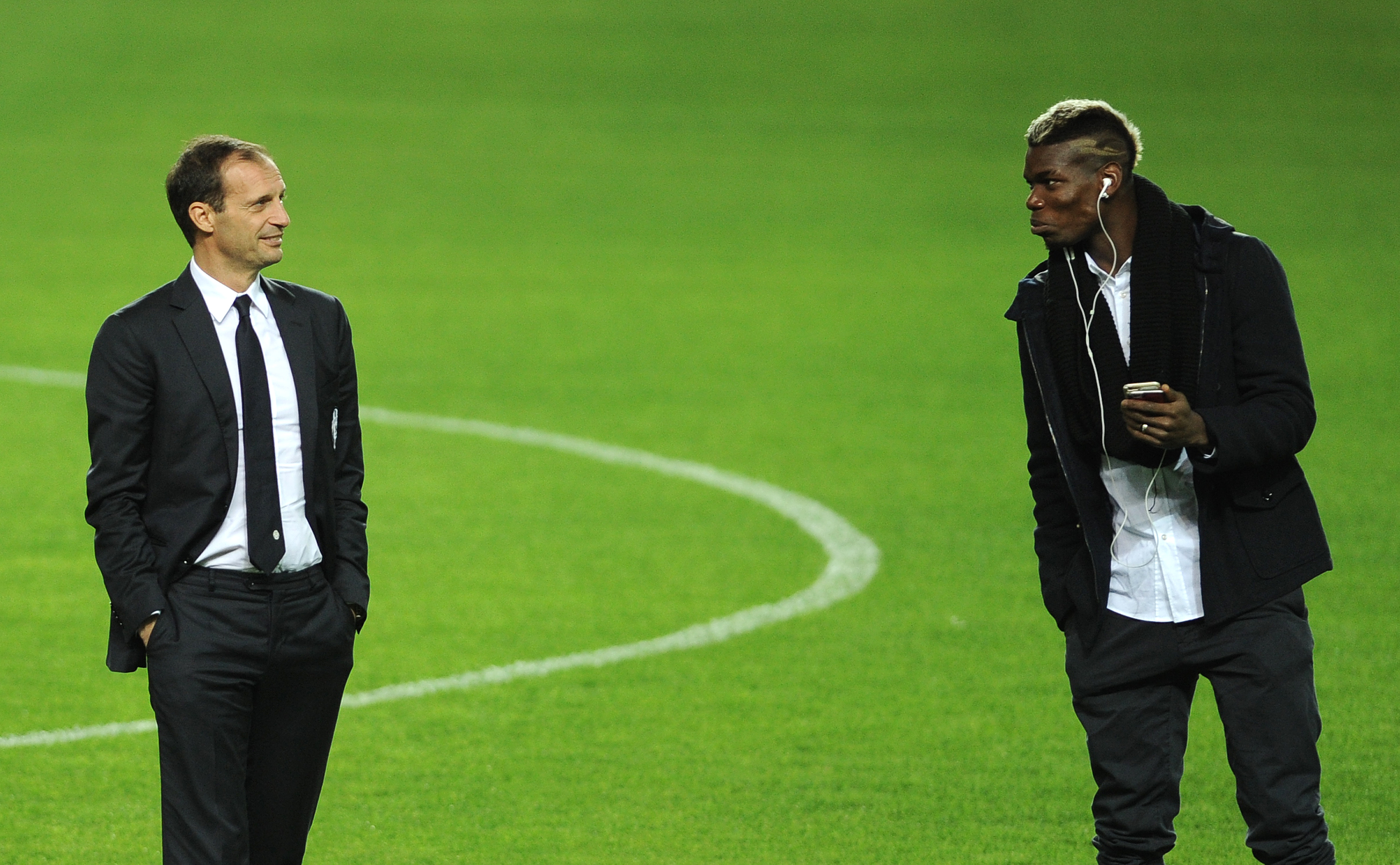 Juventus's French midfielder Paul Pogba (R) speaks with Juventus's coach Italian Massimiliano Allegri (L) at the Ramon Sanchez Pizjuan in Sevilla on December 7, 2015, on the eve of the UEFA Champions League Group D football match Sevilla FC vs Juventus.   AFP PHOTO/ CRISTINA QUICLER / AFP / CRISTINA QUICLER        (Photo credit should read CRISTINA QUICLER/AFP/Getty Images)