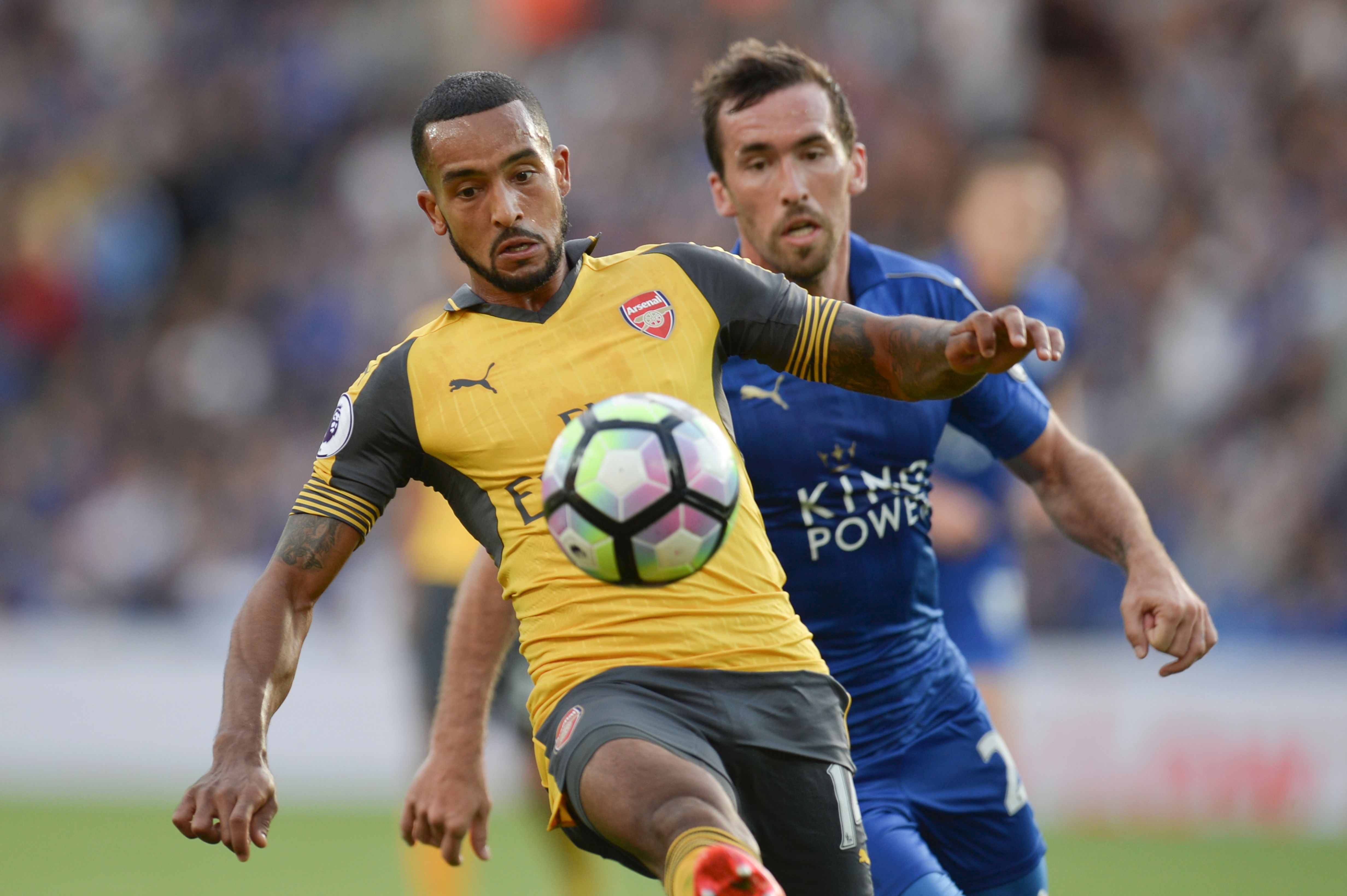 Arsenal's English midfielder Theo Walcott (L) tries to hold off Leicester City's Austrian defender Christian Fuchs (R) during the English Premier League football match between Leicester City and Arsenal at King Power Stadium in Leicester, central England on August 20, 2016.  (Photo credit: Oli Scarff/AFP/Getty Images)