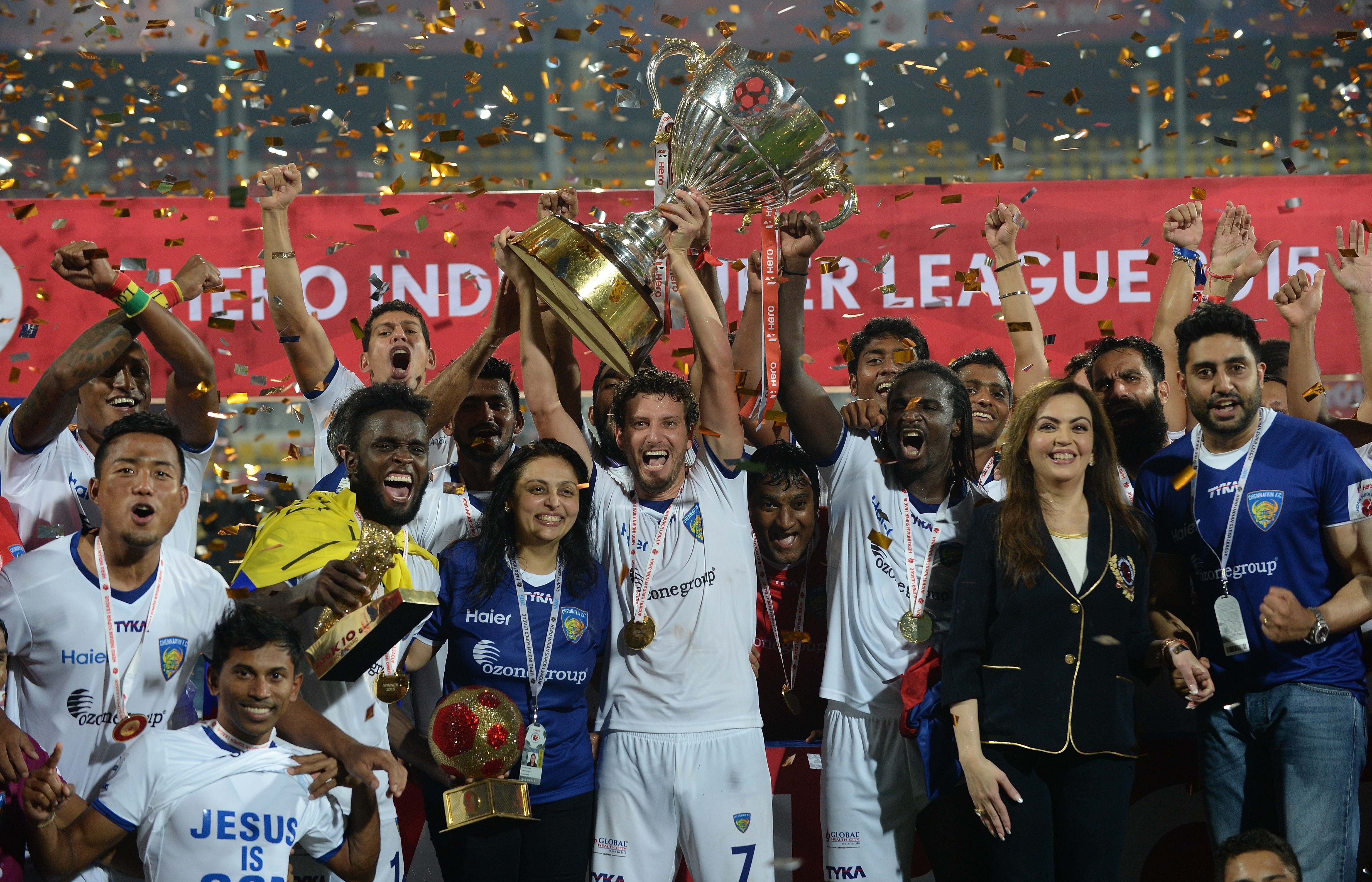 Chennaiyin FC players pose with the trophy as they celebrate along with Bollywood actor Abhishek Bachchan (R) and Nita Ambani (3R) after winning the final match against FC Goa during the Indian Super League (ISL) football tournament at Jawahar Lal Nehru Stadium in Goa on December 20, 2015.  AFP PHOTO / PUNIT PARANJPE / AFP / PUNIT PARANJPE        (Photo credit should read PUNIT PARANJPE/AFP/Getty Images)