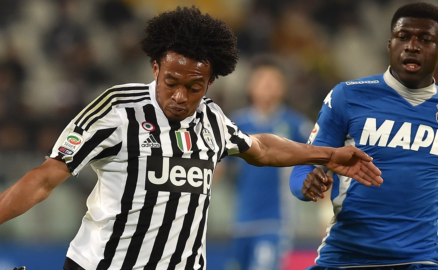 TURIN, ITALY - MARCH 11:  Juan Cuadrado (L) of Juventus FC in action against Alfred Duncan of US Sassuolo Calcio during the Serie A match between Juventus FC and US Sassuolo Calcio at Juventus Arena on March 11, 2016 in Turin, Italy.  (Photo by Valerio Pennicino/Getty Images)