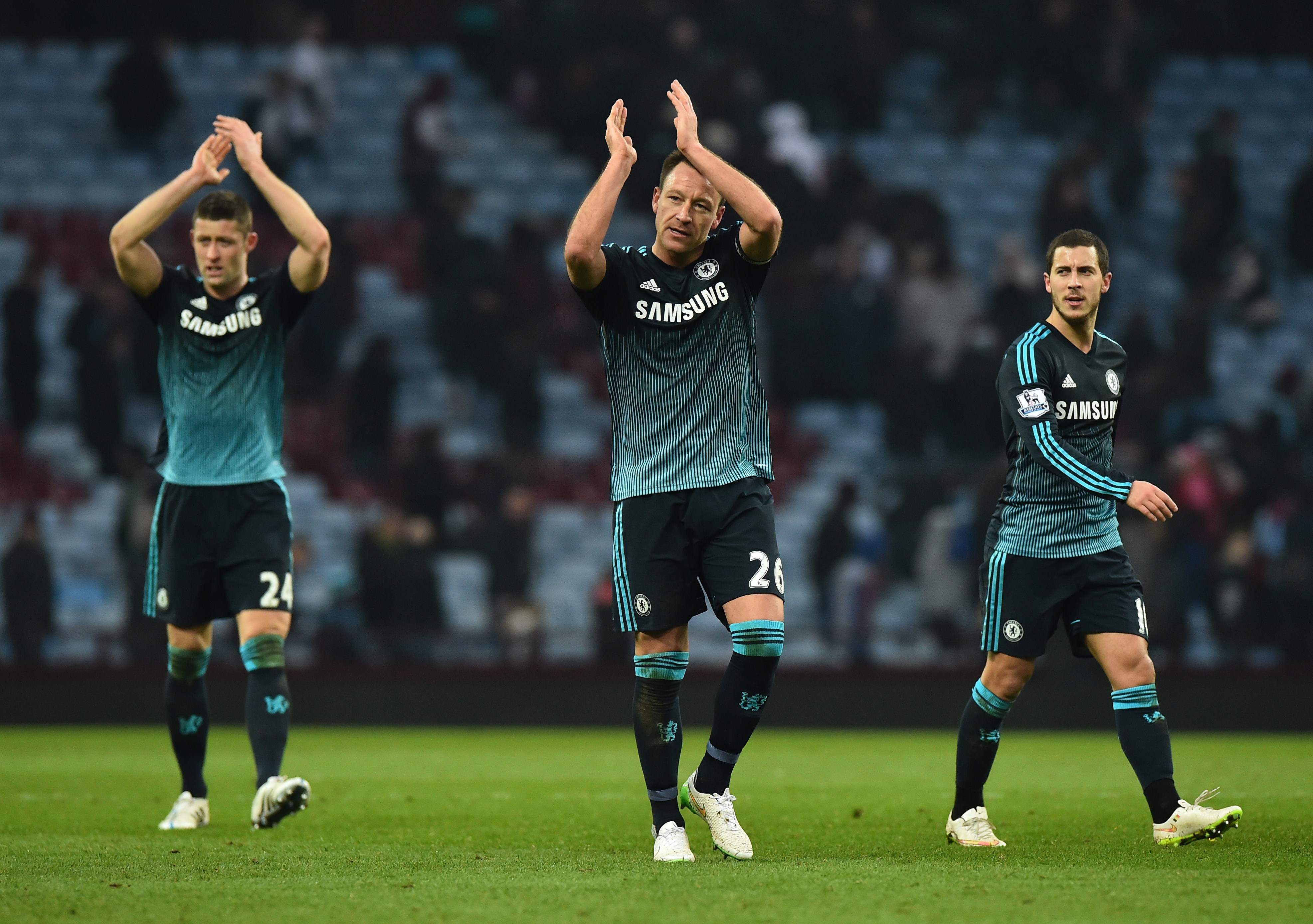 Chelsea's English defender John Terry (C), Chelsea's English defender Gary Cahill (L) and Chelsea's Belgian midfielder Eden Hazard (R) gesture to supporters after the English Premier League football match between Aston Villa and Chelsea at Villa Park in Birmingham, central England on February 7, 2015. Chelsea won the game 2-1. AFP PHOTO / BEN STANSALL

RESTRICTED TO EDITORIAL USE. No use with unauthorized audio, video, data, fixture lists, club/league logos or "live" services. Online in-match use limited to 45 images, no video emulation. No use in betting, games or single club/league/player publications.        (Photo credit should read BEN STANSALL/AFP/Getty Images)