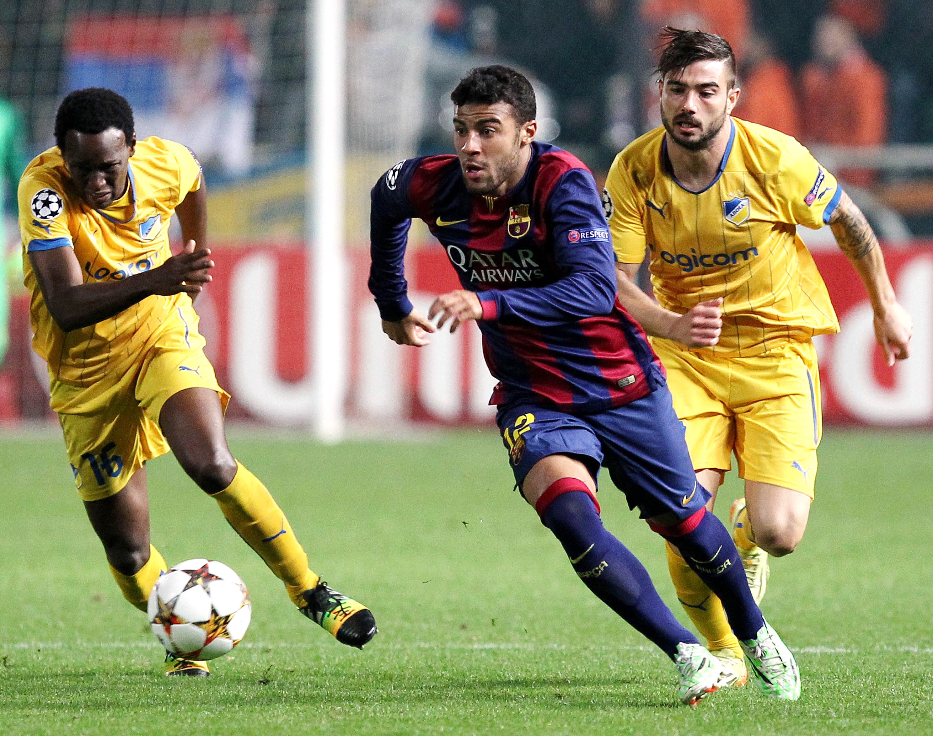 Barcelona's Brazilian midfielder Rafinha (C) vies for the ball  against APOEL FC's Mario Sergio  (R) and Brazilian midfielder Vinicius  during their UEFA Champions League football match at the Neo GSP Stadium in the Cypriot capital, Nicosia, on November 25, 2014. AFP PHOTO/ SAKIS SAVVIDES        (Photo credit should read SAKIS SAVVIDES/AFP/Getty Images)