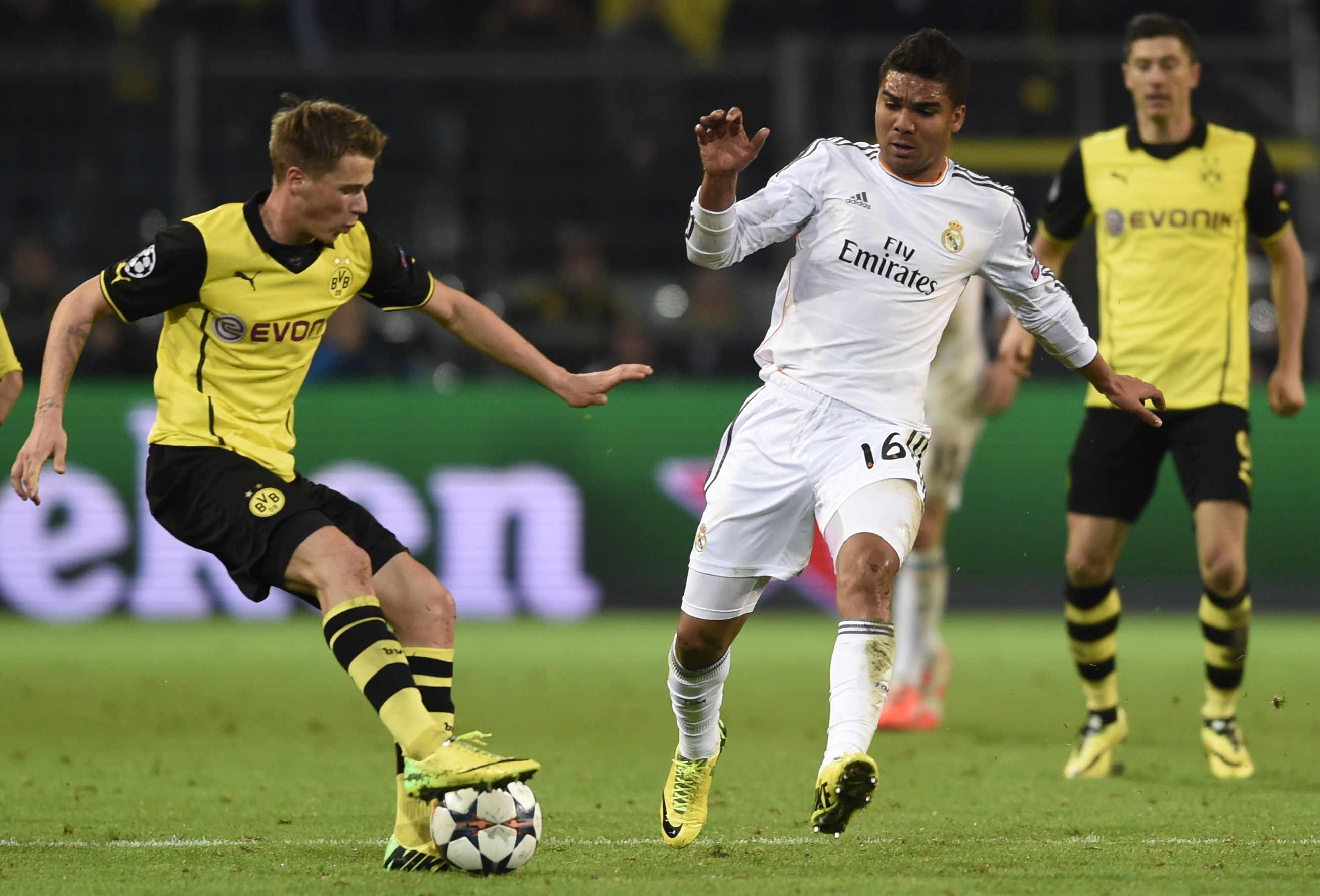 Real Madrid's Brazilian midfielder Carlos Henrique Casemiro (C) and Dortmund's defender Oliver Kirch vie for the ball during the UEFA Champions League quarter-final, second leg football match Borussia Dortmund vs Real Madrid CF on April 8, 2014 in Dortmund, western Germany.    AFP PHOTO / ODD ANDERSEN        (Photo credit should read ODD ANDERSEN/AFP/Getty Images)