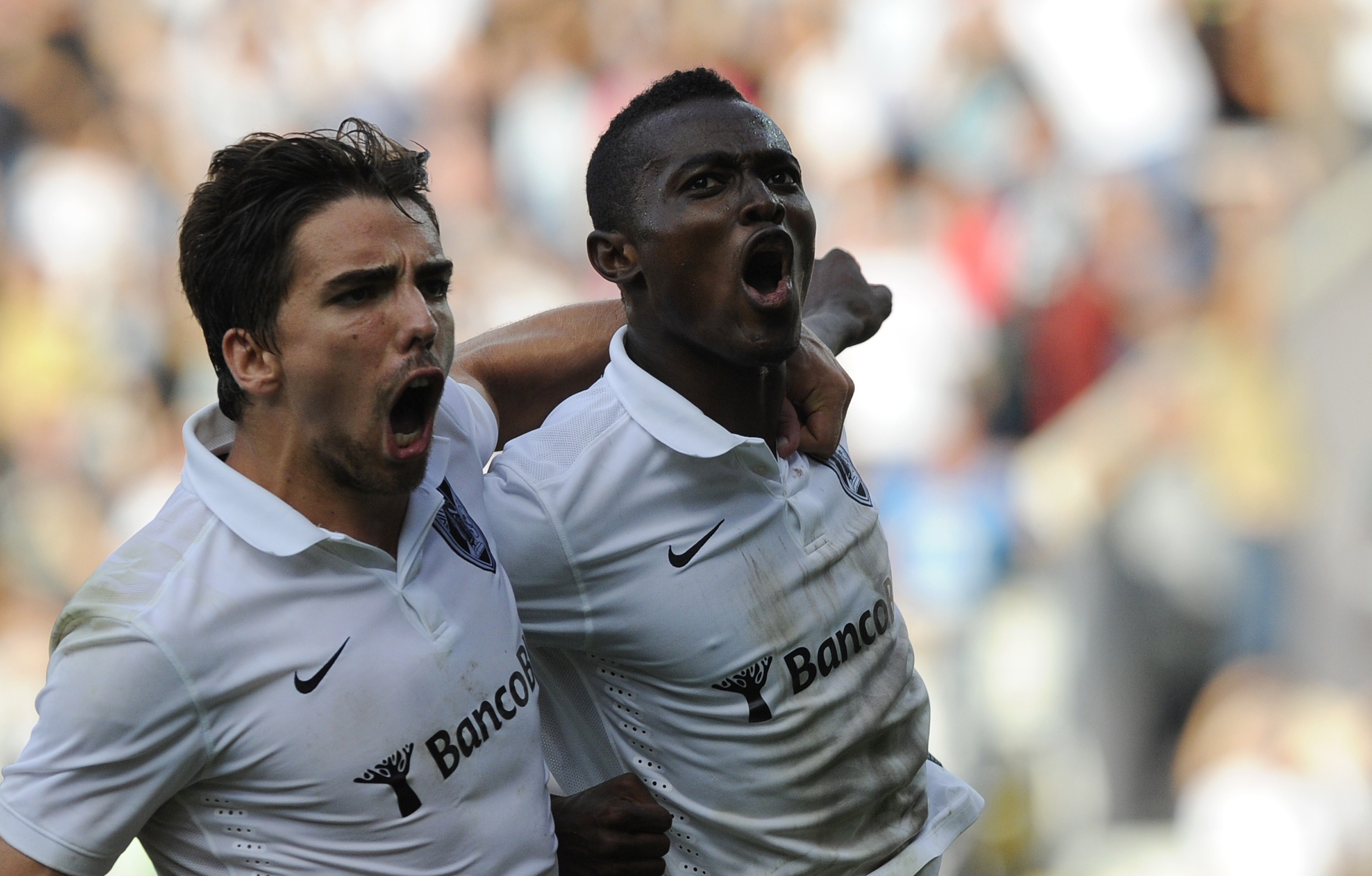 Vitoria SC's Ghanaian midfielder Bernard Mensah (R) celebrates with his teammate forward Tomane after scoring during the Portuguese league football match Vitoria SC vs FC Porto at the Afonso Henriques Stadium in Guimaraes on September 14, 2014.  AFP PHOTO/ MIGUEL RIOPA        (Photo credit should read MIGUEL RIOPA/AFP/Getty Images)