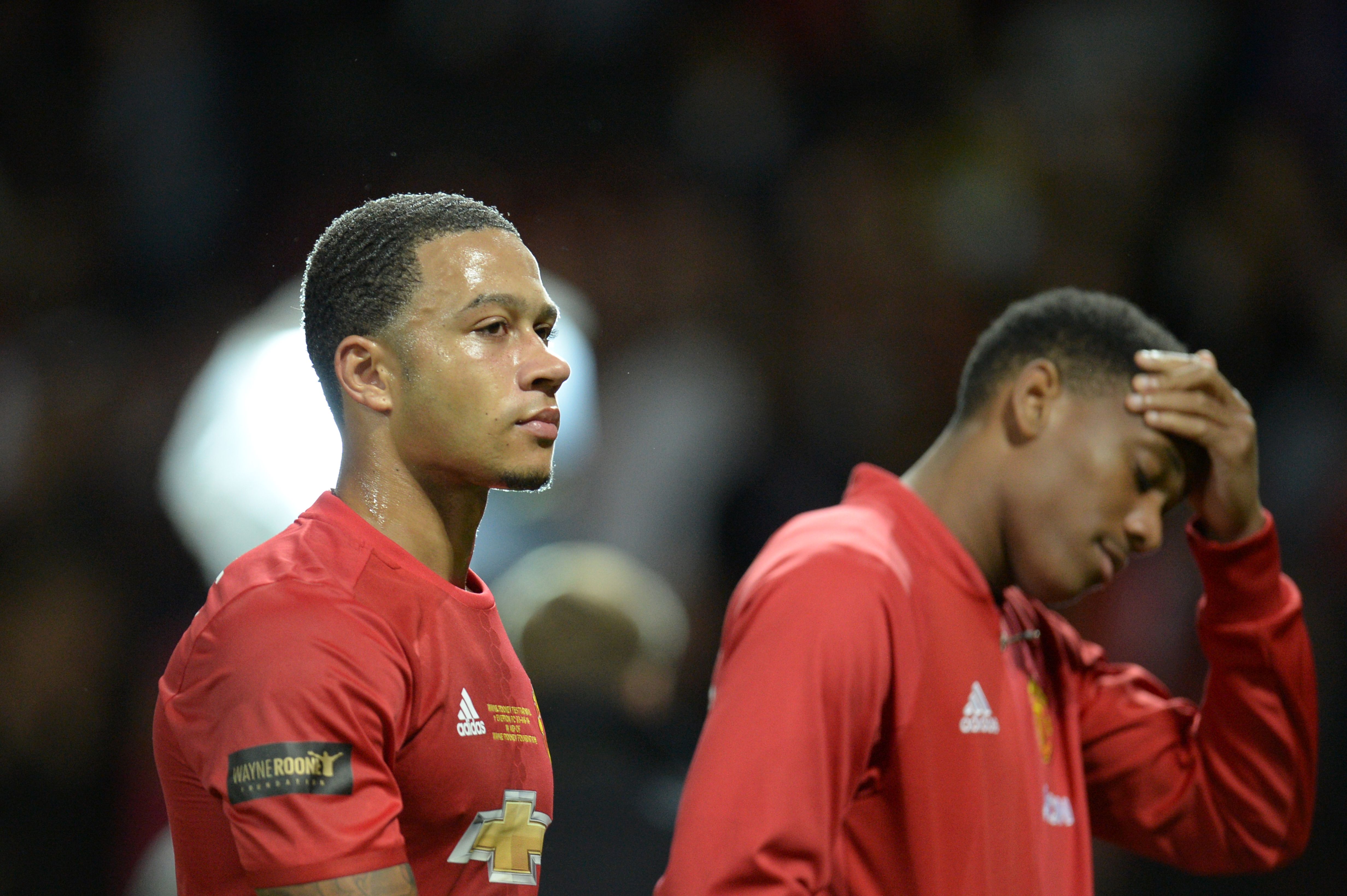 Manchester United's Dutch midfielder Memphis Depay (L) and Manchester United's French striker Anthony Martial (R) leave the pitch at the end of the friendly Wayne Rooney testimonial football match between Manchester United and Everton at Old Trafford in Manchester, northwest England, on August 3, 2016.  / AFP / OLI SCARFF        (Photo credit should read OLI SCARFF/AFP/Getty Images)