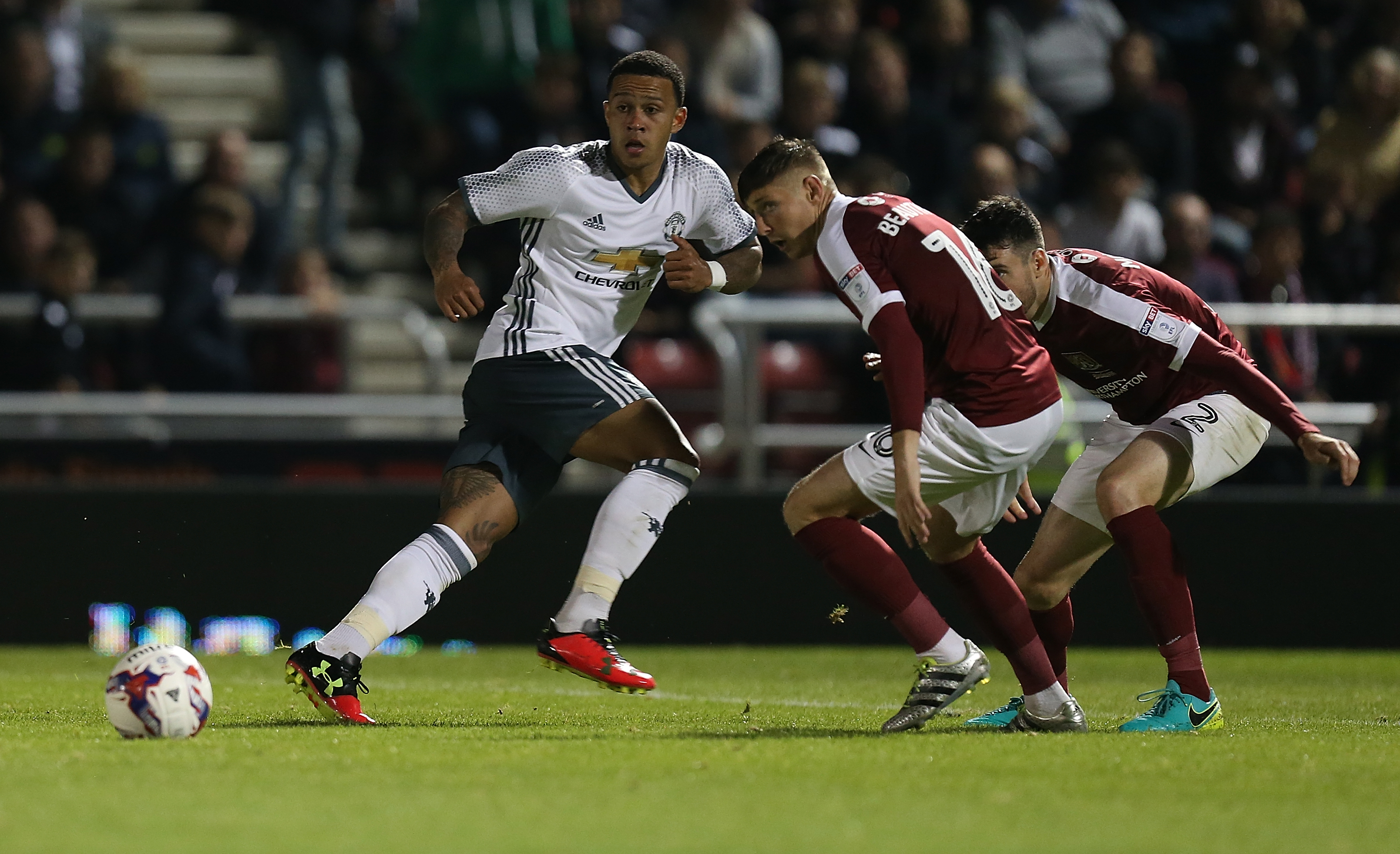NORTHAMPTON, ENGLAND - SEPTEMBER 21:  Memphis Depay of Manchester United looks to the ball with Harry Beautyman and Brendan Moloney of Northampton Town during the  EFL Cup Third Round match between Northampton Town and Mancester United at Sixfields Stadium on September 21, 2016 in Northampton, England.  (Photo by Pete Norton/Getty Images)