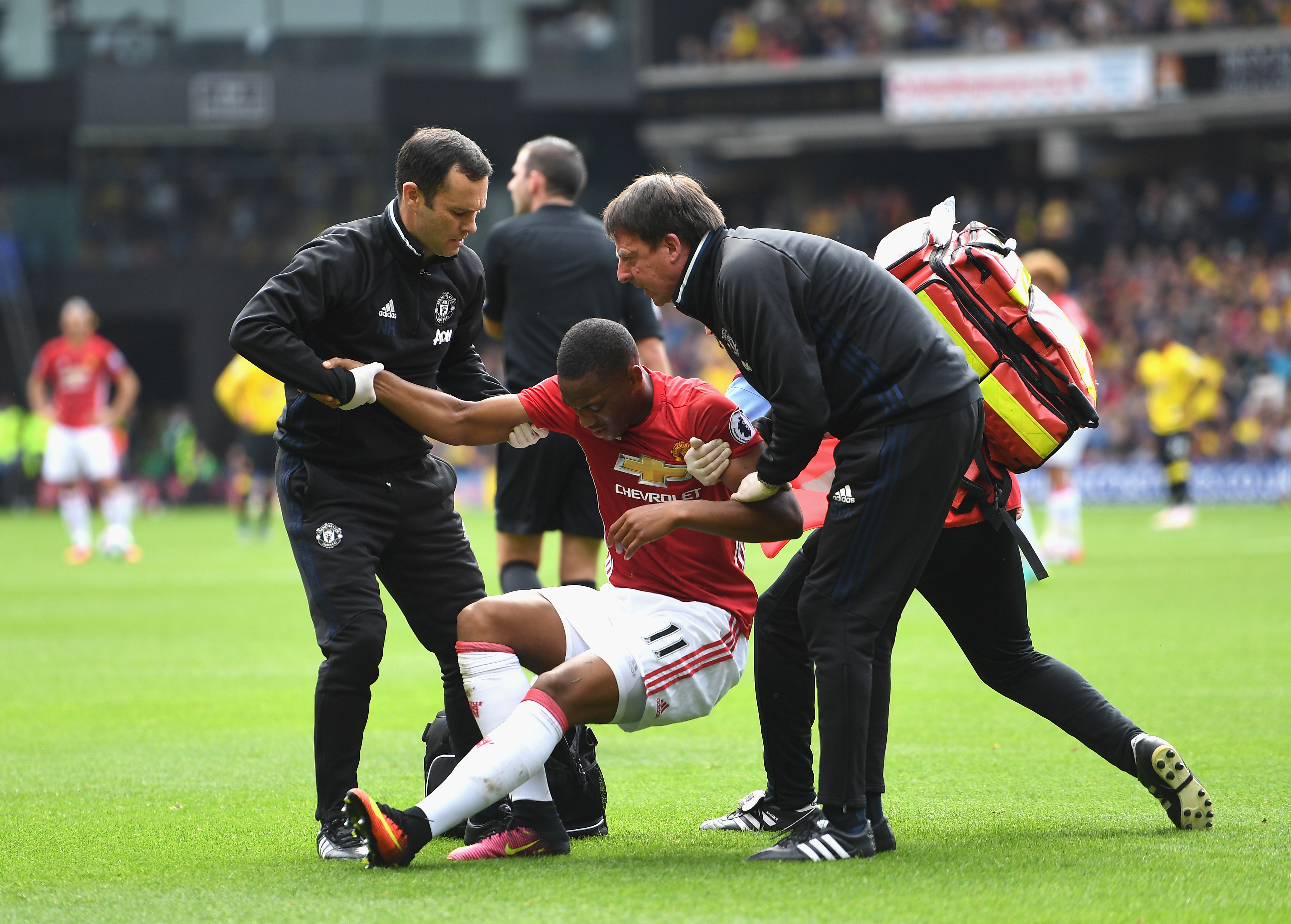 WATFORD, ENGLAND - SEPTEMBER 18: The Manchester United medical staff help Anthony Martial of Manchester United up after being injured  during the Premier League match between Watford and Manchester United at Vicarage Road on September 18, 2016 in Watford, England.  (Photo by Laurence Griffiths/Getty Images)