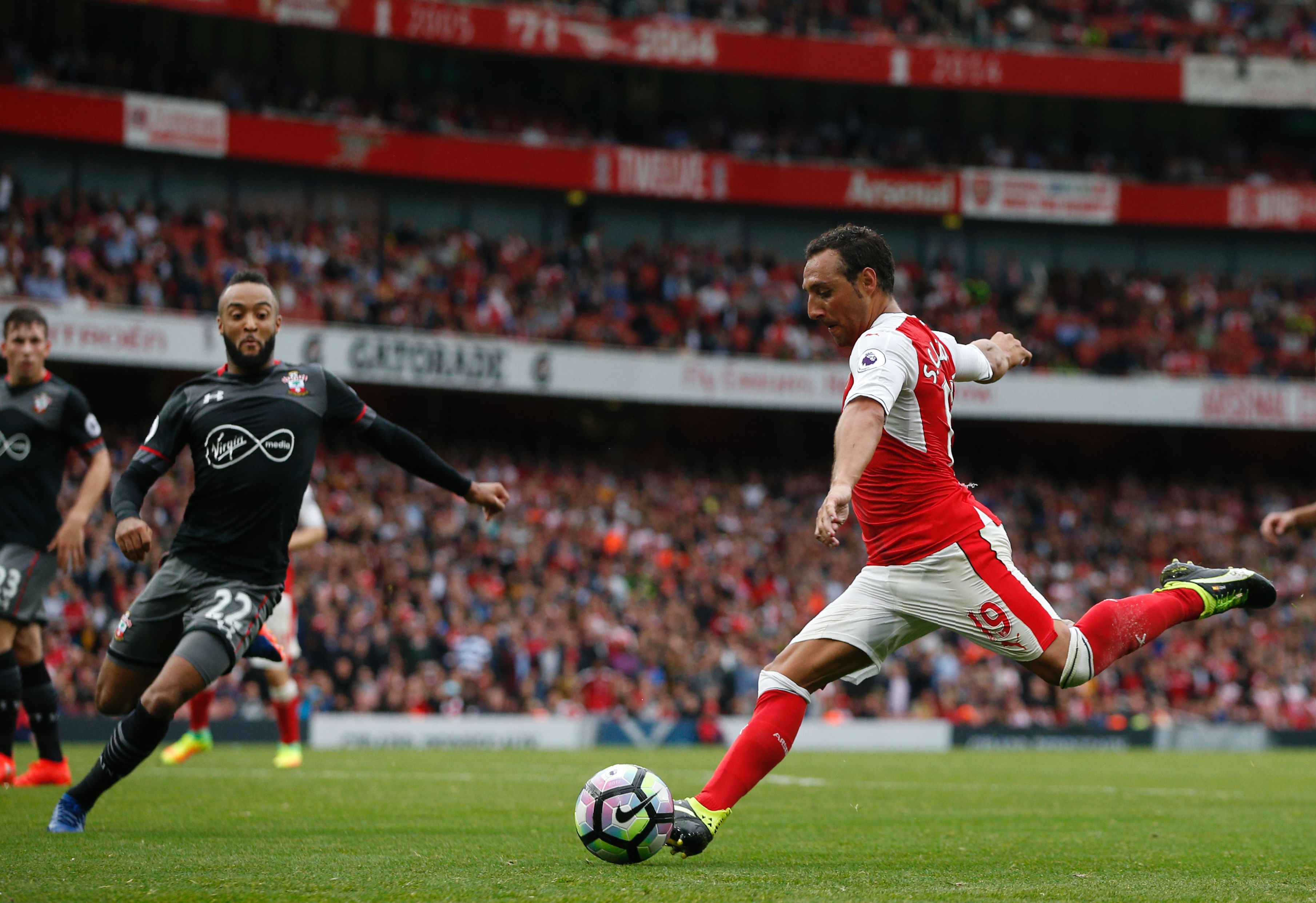Arsenal's Spanish midfielder Santi Cazorla (R) crosses the ball during the English Premier League football match between Arsenal and Southampton at the Emirates Stadium in London on September 10, 2016.  / AFP / Adrian DENNIS / RESTRICTED TO EDITORIAL USE. No use with unauthorized audio, video, data, fixture lists, club/league logos or 'live' services. Online in-match use limited to 75 images, no video emulation. No use in betting, games or single club/league/player publications.  /         (Photo credit should read ADRIAN DENNIS/AFP/Getty Images)
