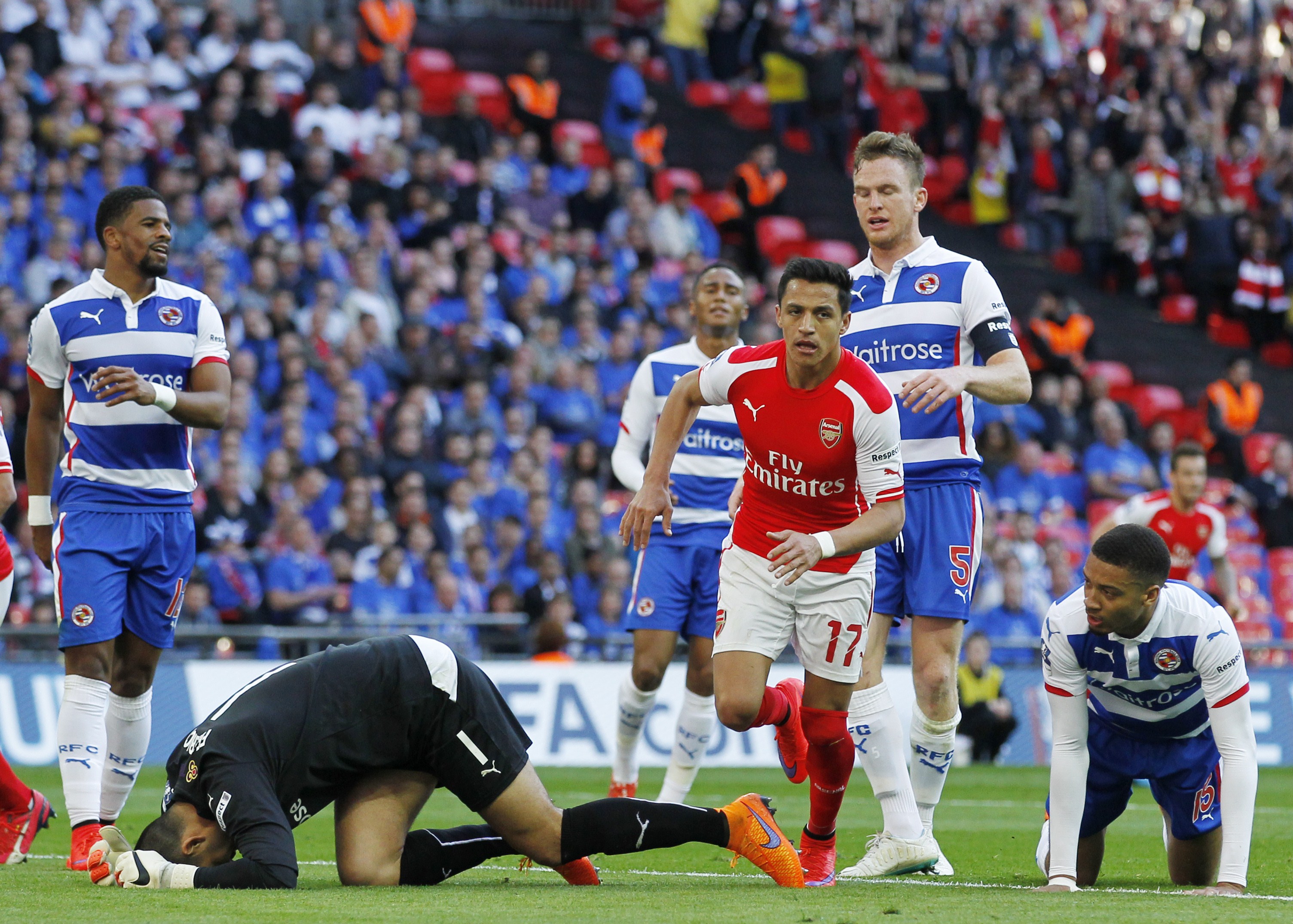 Arsenal's Chilean striker Alexis Sanchez (C-R) runs past Reading's Australian goalkeeper Adam Federici (L) after scoring during the FA Cup semi-final between Arsenal and Reading at Wembley stadium in London on April 18, 2015.
AFP PHOTO / IAN KINGTON
NOT FOR MARKETING OR ADVERTISING USE / RESTRICTED TO EDITORIAL USE        (Photo credit should read IAN KINGTON/AFP/Getty Images)