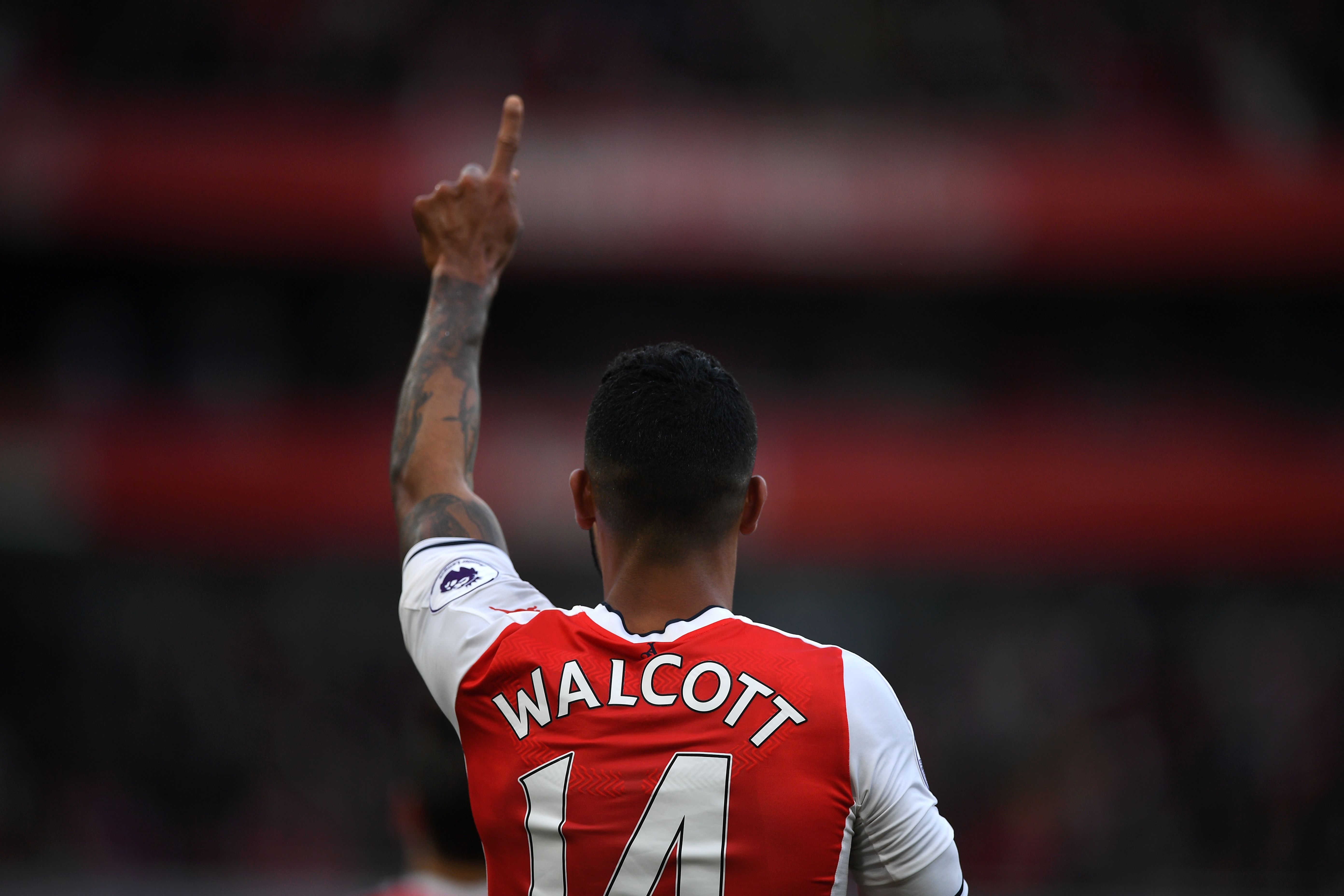 Arsenal's English midfielder Theo Walcott celebrates scoring the opening goal of the English Premier League football match between Arsenal and Swansea City at the Emirates Stadium in London on October 15, 2016. 
Arsenal won the game 3-2. / AFP / Justin TALLIS / RESTRICTED TO EDITORIAL USE. No use with unauthorized audio, video, data, fixture lists, club/league logos or 'live' services. Online in-match use limited to 75 images, no video emulation. No use in betting, games or single club/league/player publications.  /         (Photo credit should read JUSTIN TALLIS/AFP/Getty Images)