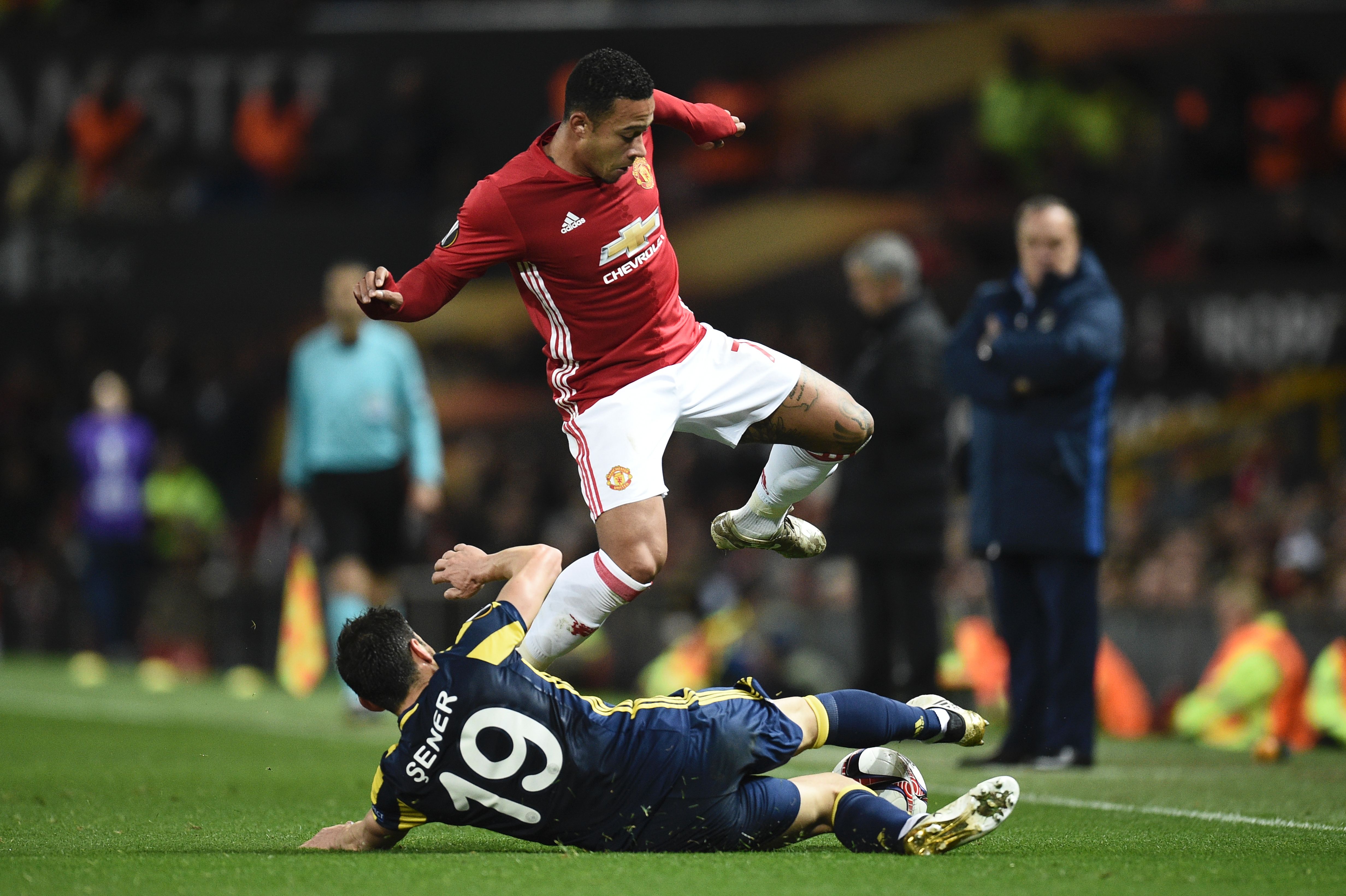 Fenerbahce's Turkish defender Sener Ozbayrakli (floor) slides to tackle Manchester United's Dutch midfielder Memphis Depay (top) during the UEFA Europa League group A football match between Manchester United and Fenerbahce at Old Trafford in Manchester, north west England, on October 20, 2016. / AFP / OLI SCARFF        (Photo credit should read OLI SCARFF/AFP/Getty Images)