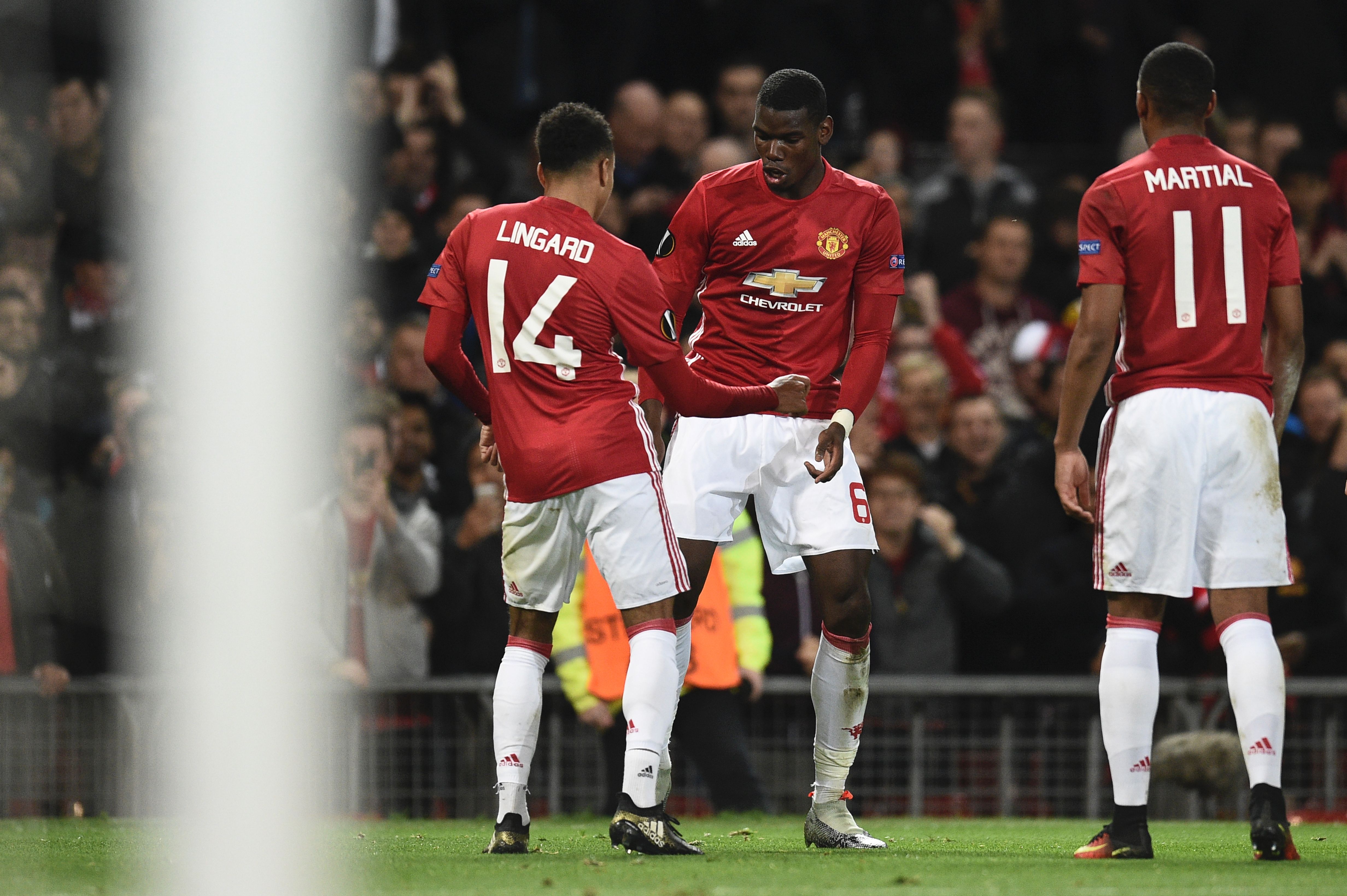 Manchester United's French midfielder Paul Pogba (C) and Manchester United's English midfielder Jesse Lingard (L) do a celebration dance after Pogba scored their third goal during the UEFA Europa League group A football match between Manchester United and Fenerbahce at Old Trafford in Manchester, north west England, on October 20, 2016. / AFP / OLI SCARFF        (Photo credit should read OLI SCARFF/AFP/Getty Images)