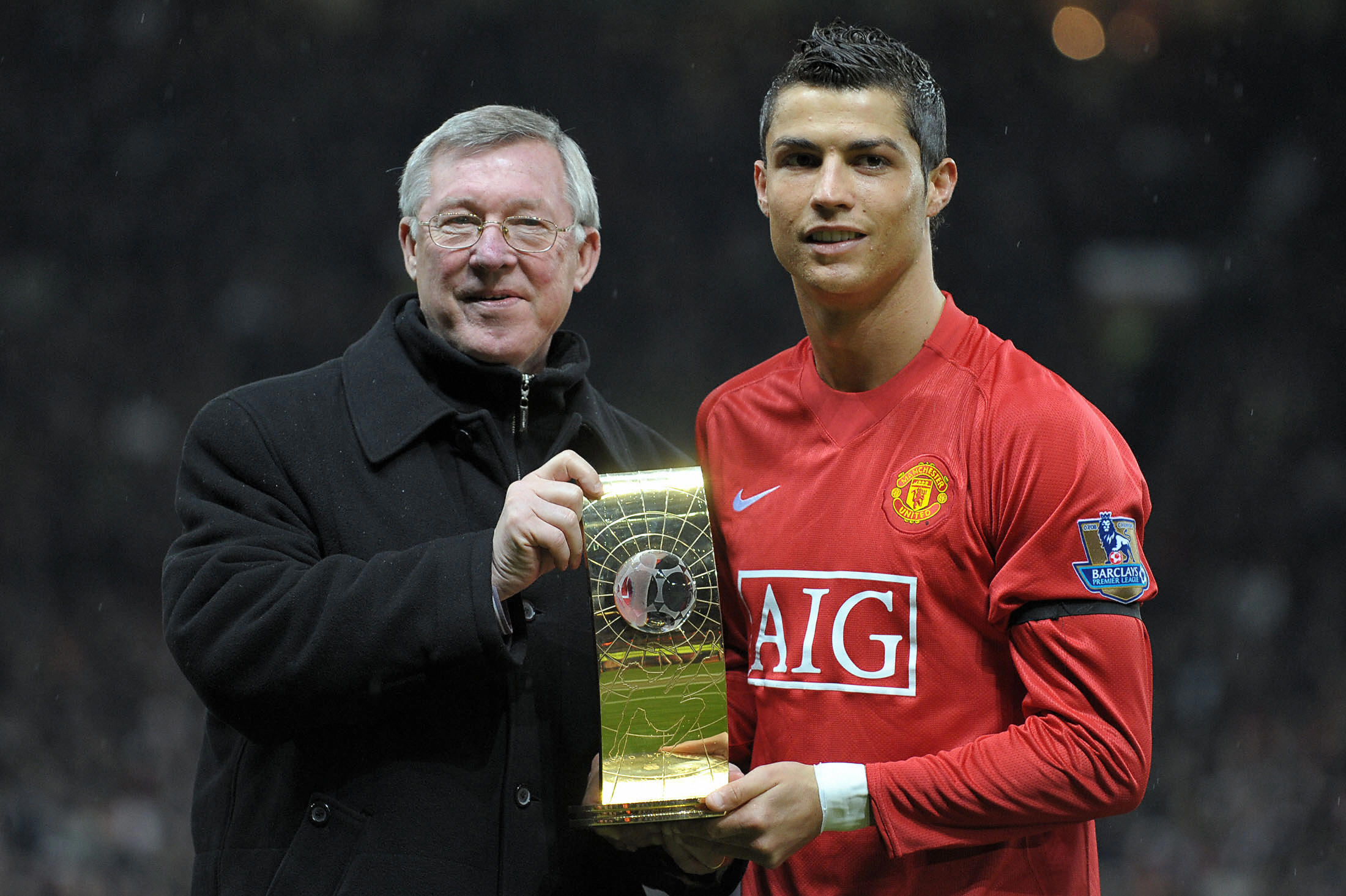 Manchester United's Portuguese midfielder Cristiano Ronaldo (R) poses with his FIFA world player of the year trophy with Manager Alex Ferguson before the English Premiership football match against Wigan at Old Trafford, Manchester, north-west England, on January 14, 2009.   AFP PHOTO/ ANDREW YATES FOR EDITORIAL USE ONLY Additional licence required for any commercial/promotional use or use on TV or internet (except identical online version of newspaper) of Premier League/Football League photos. Tel DataCo +44 207 2981656. Do not alter/modify photo. (Photo credit should read ANDREW YATES/AFP/Getty Images)