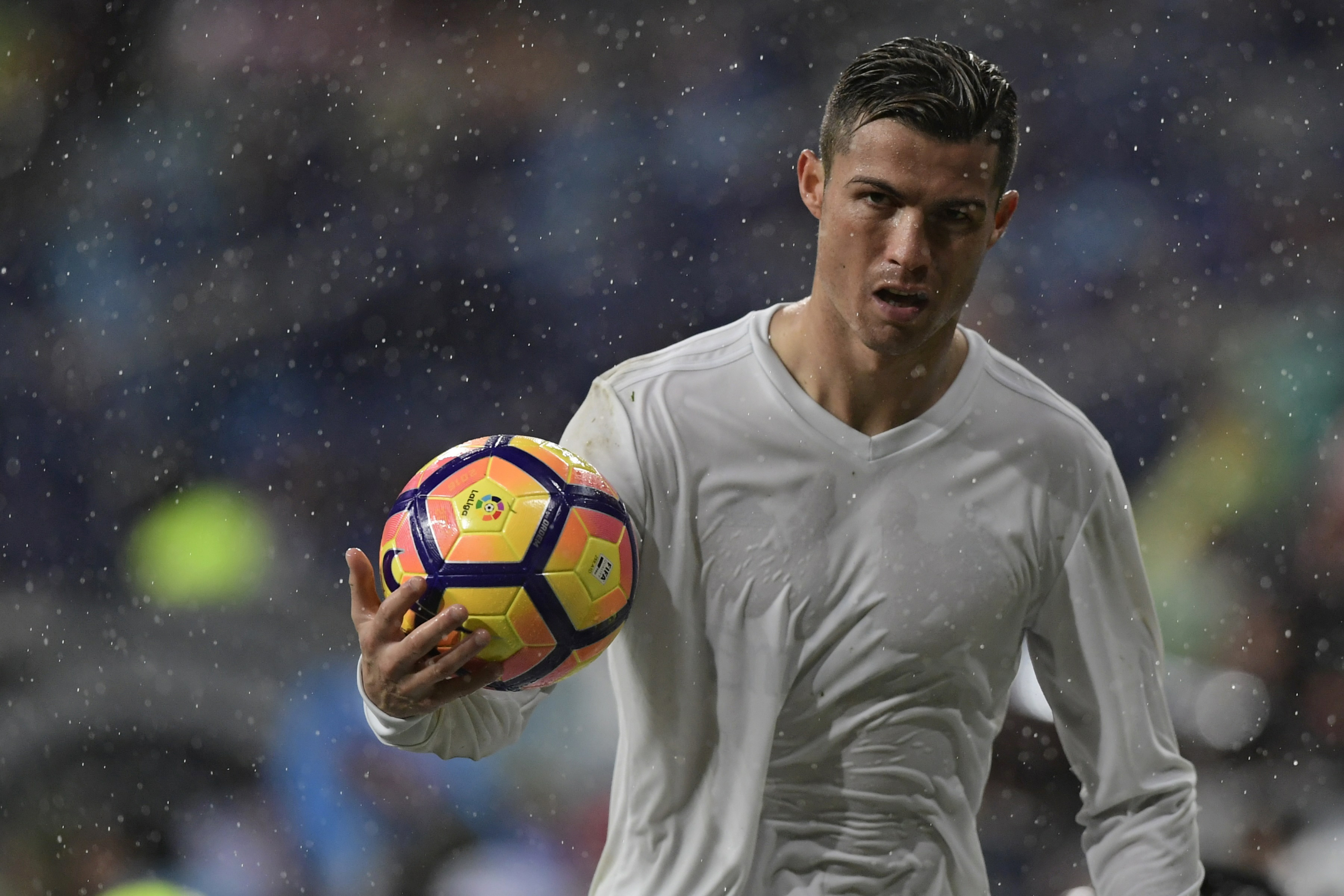 Real Madrid's Portuguese forward Cristiano Ronaldo holds a ball during the Spanish league football match Real Madrid CF vs Sporting de Gijon SAD at the Santiago Bernabeu stadium in Madrid on November 26, 2016. / AFP / JAVIER SORIANO        (Photo credit should read JAVIER SORIANO/AFP/Getty Images)