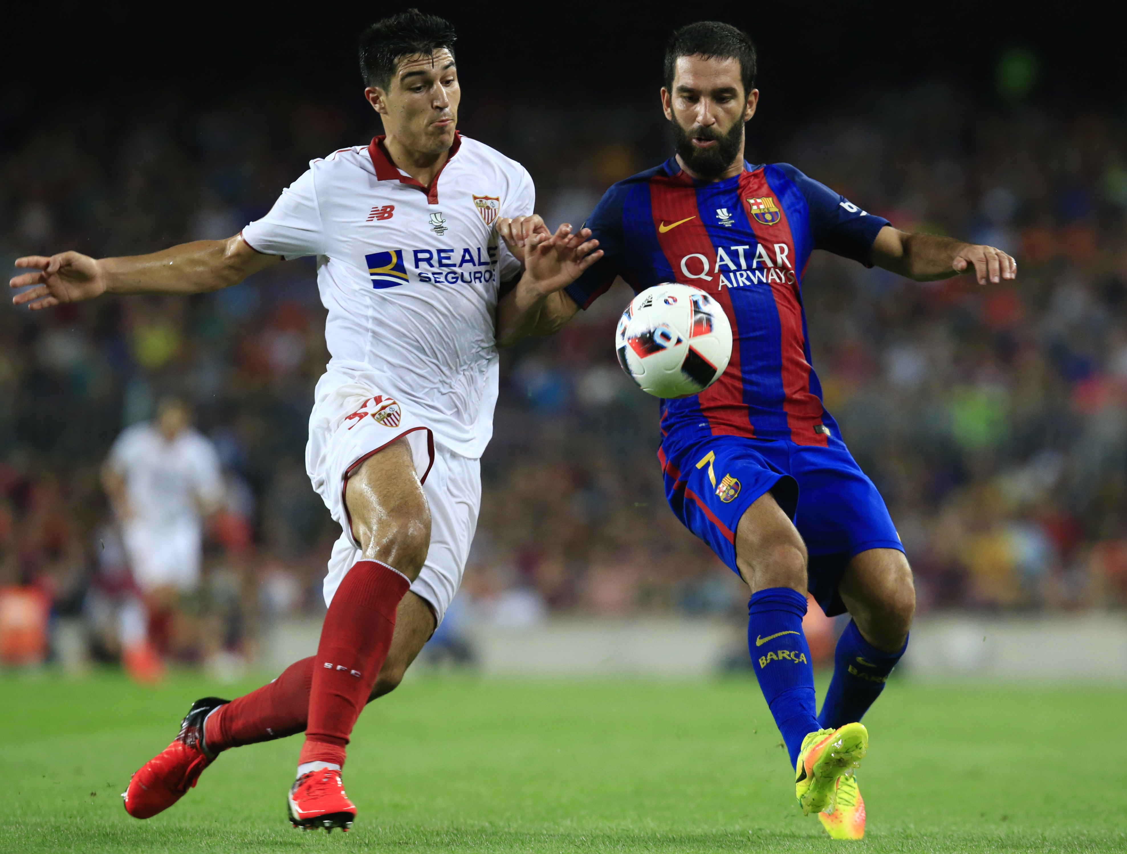 Sevilla's defender Diego Glez (L) vies with Barcelona's Turkish midfielder Arda Turan during the second leg of the Spanish Supercup football match between FC Barcelona and Sevilla FC at the Camp Nou stadium in Barcelona on August 17, 2016. / AFP / PAU BARRENA        (Photo credit should read PAU BARRENA/AFP/Getty Images)