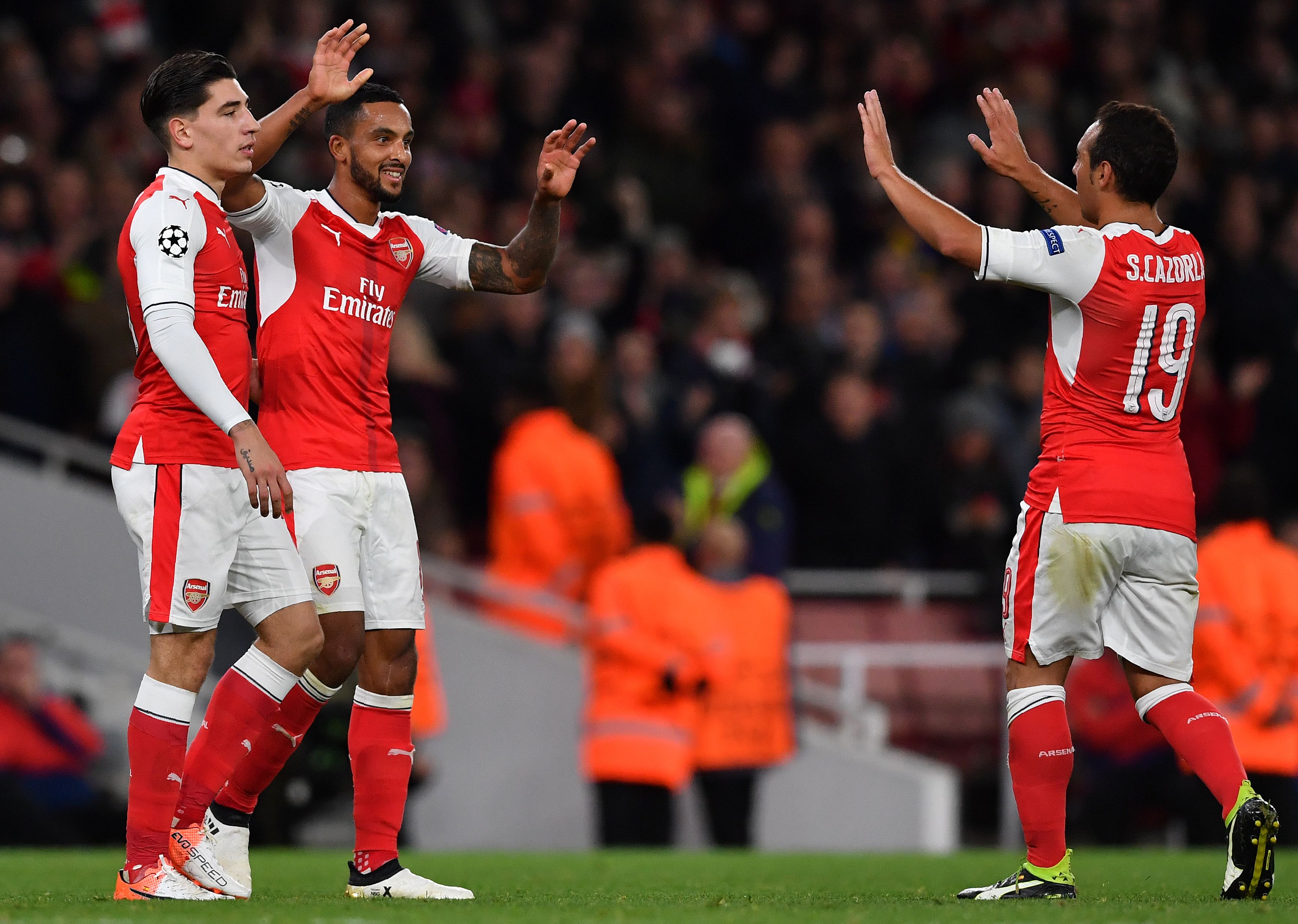 Arsenal's English midfielder Theo Walcott (C) celebrates scoring his team's second goal with Arsenal's Spanish defender Hector Bellerin (L) and Arsenal's Spanish midfielder Santi Cazorla during the UEFA Champions League Group A football match between Arsenal and Ludogorets Razgrad at The Emirates Stadium in London on October 19, 2016. / AFP / BEN STANSALL        (Photo credit should read BEN STANSALL/AFP/Getty Images)