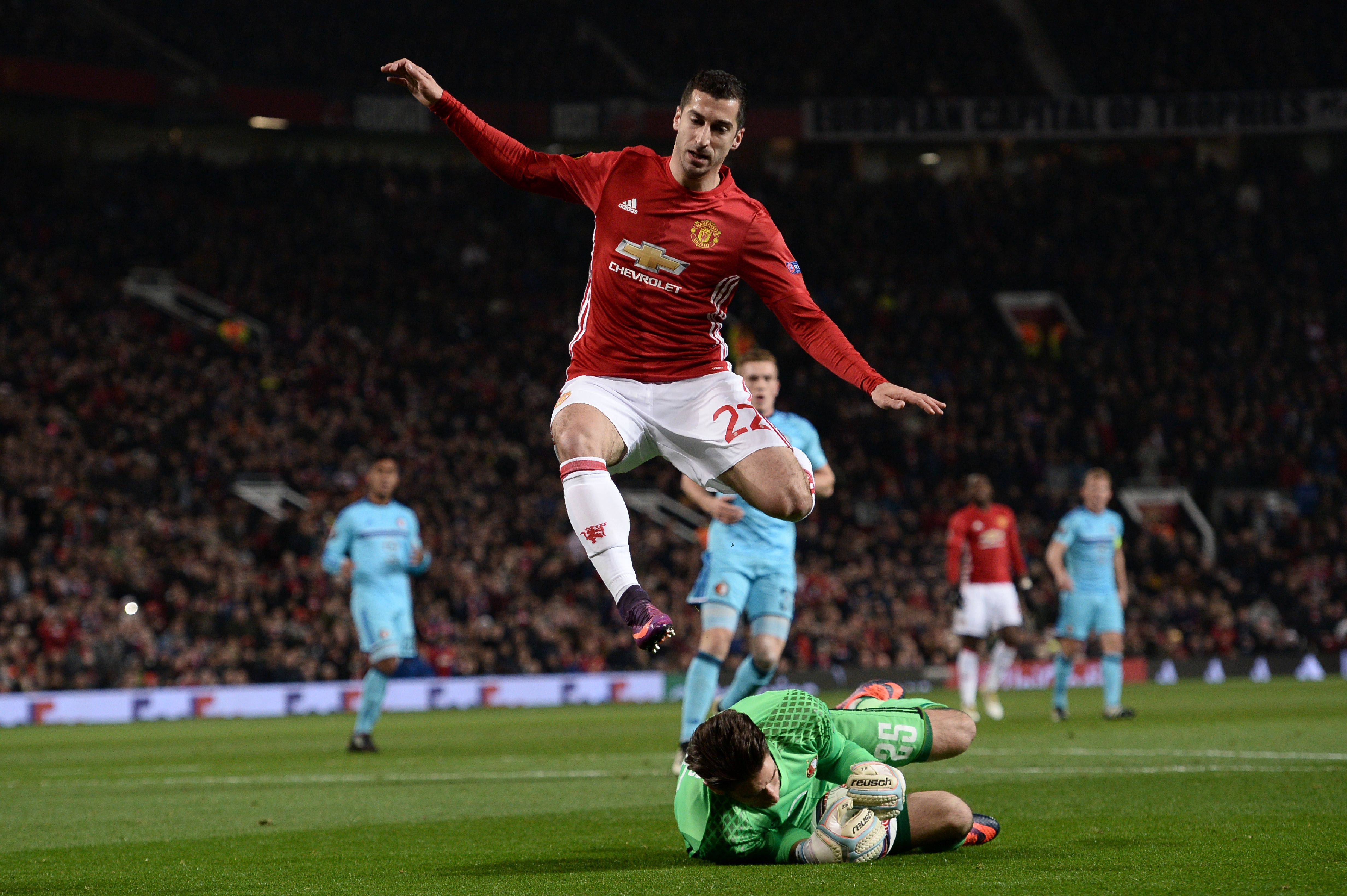 Feyenoord's Australian goalkeeper Brad Jones (floor) claims the ball ahead of Manchester United's Armenian midfielder Henrikh Mkhitaryan (top) during the UEFA Europa League group A football match between Manchester United and Feyenoord at Old Trafford stadium in Manchester, north-west England, on November 24, 2016. (Photo by OLI SCARFF/AFP/Getty Images)