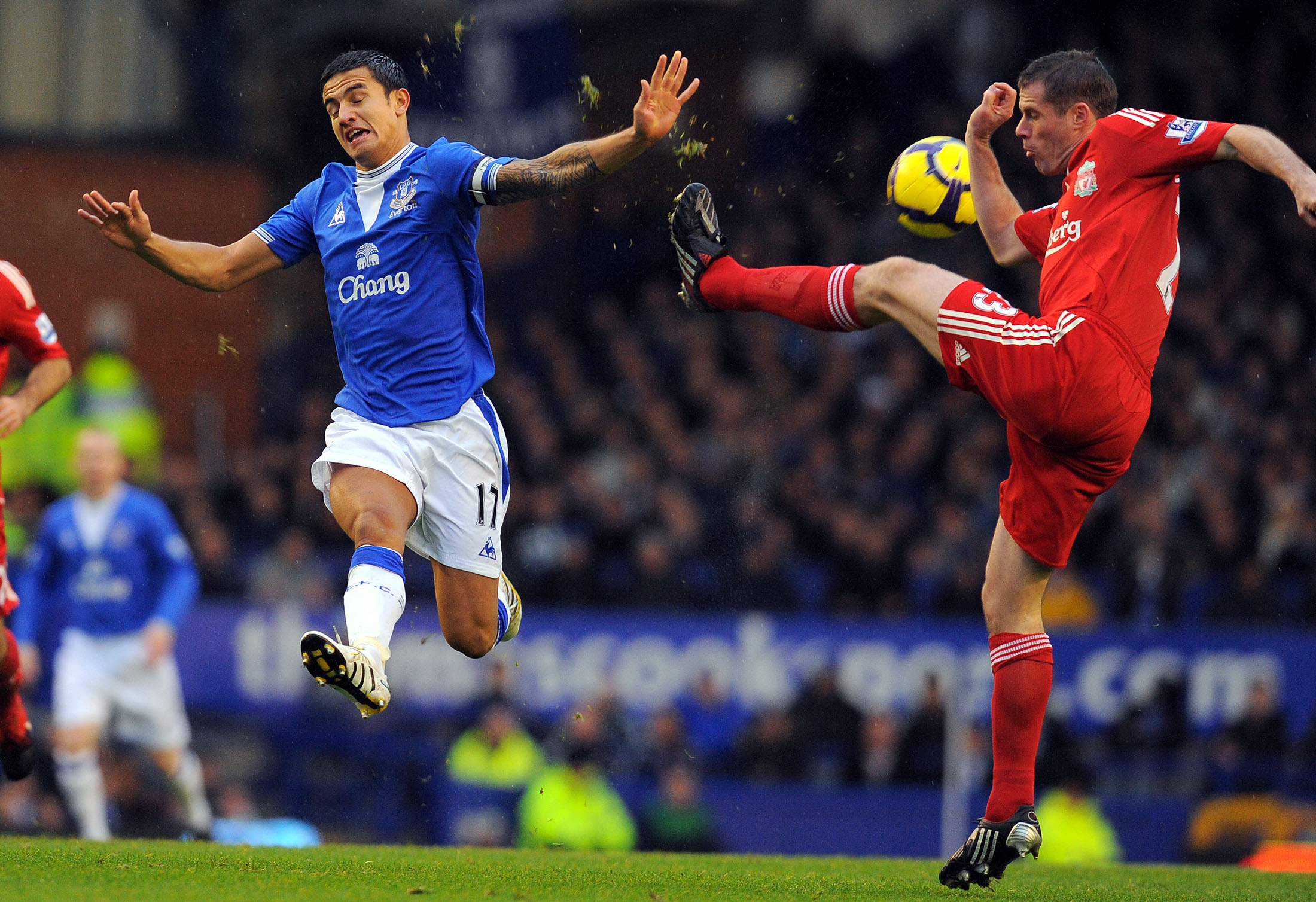 Everton's Australian midfielder Tim Cahill (L) challenges Liverpool's English defender Jamie Carragher during the English Premier League football match at Goodison Park in Liverpool, north-west England on November 29, 2009. AFP PHOTO/ANDREW YATES --- RESTRICTED TO EDITORIAL USE Additional licence required for any commercial/promotional use or use on TV or internet (except identical online version of newspaper) of Premier League/Football League photos. Tel DataCo +44 207 2981656. Do not alter/modify photo (Photo credit should read -/AFP/Getty Images)