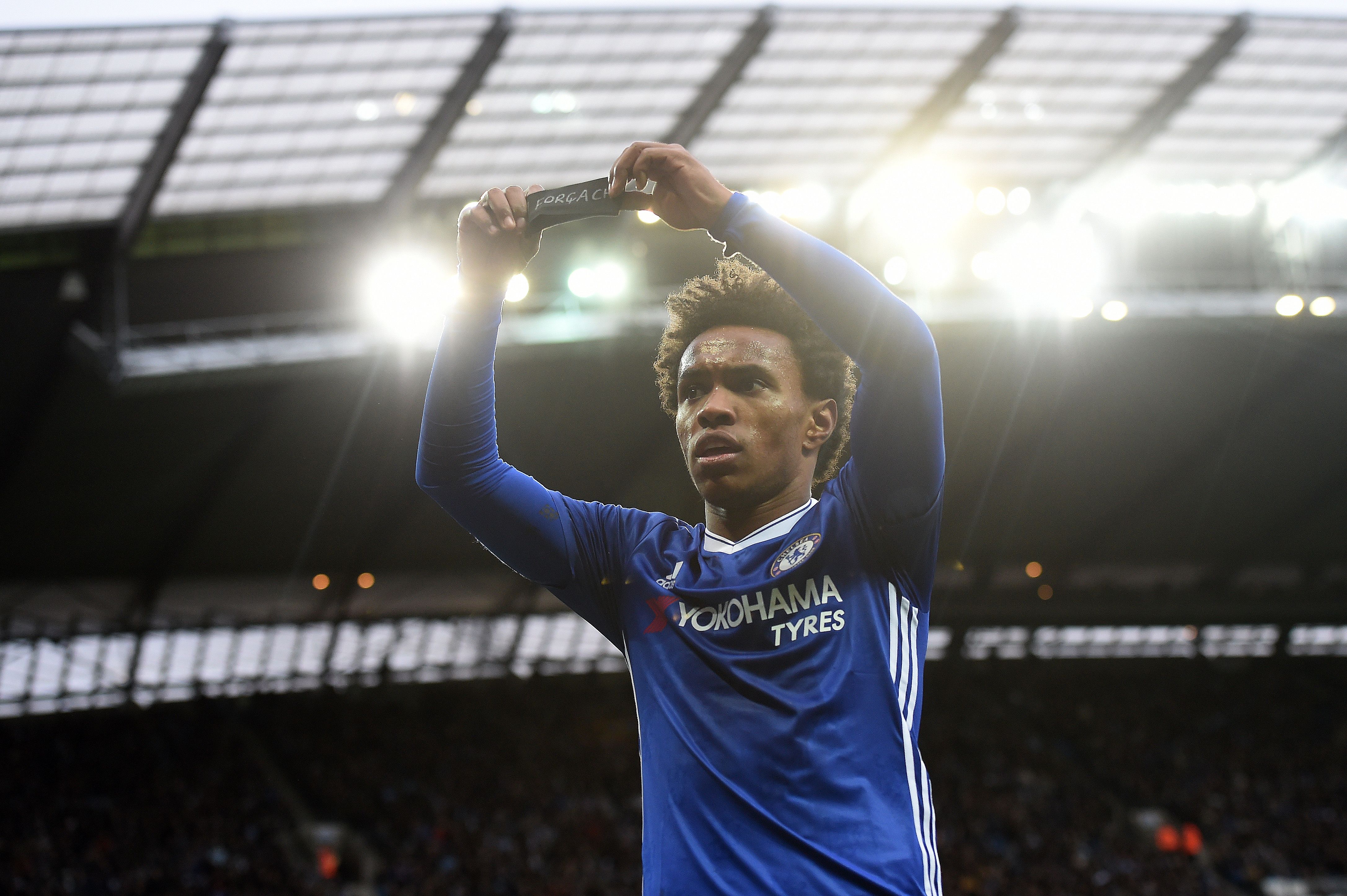 Chelsea's Brazilian midfielder Willian holds up his black armband as he celebrates scoring his team's second goal during the English Premier League football match between Manchester City and Chelsea at the Etihad Stadium in Manchester, north west England, on December 3, 2016.  / AFP / Paul ELLIS / RESTRICTED TO EDITORIAL USE. No use with unauthorized audio, video, data, fixture lists, club/league logos or 'live' services. Online in-match use limited to 75 images, no video emulation. No use in betting, games or single club/league/player publications.  /         (Photo credit should read PAUL ELLIS/AFP/Getty Images)
