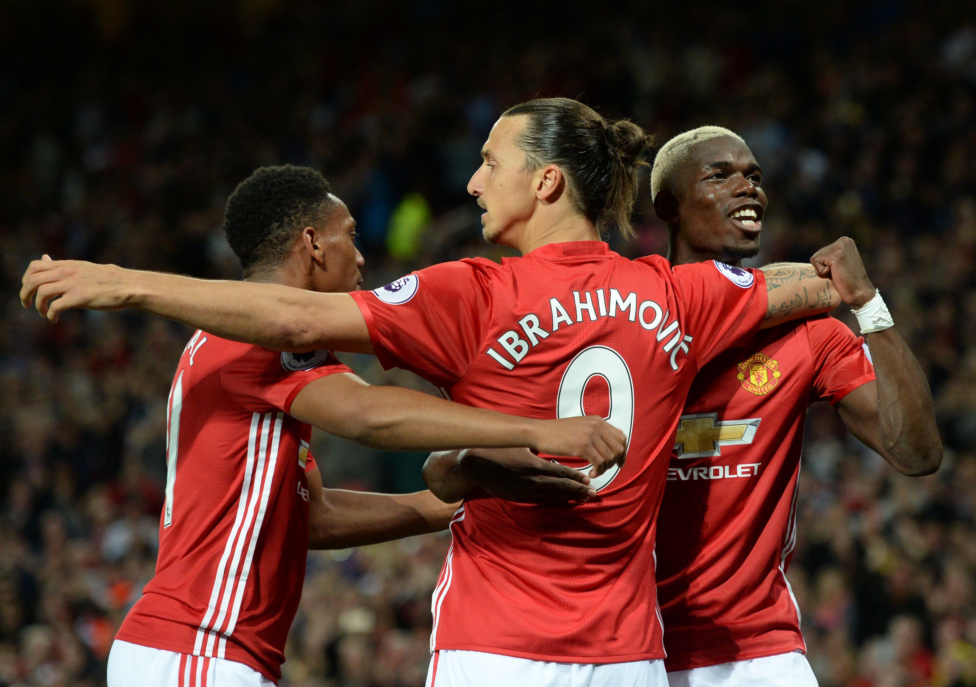 Manchester United's Swedish striker Zlatan Ibrahimovic (C) celebrates with Manchester United's French midfielder Paul Pogba (R) and Manchester United's French striker Anthony Martial after scoring their second goal from the penalty spot during the English Premier League football match between Manchester United and Southampton at Old Trafford in Manchester, north west England, on August 19, 2016. / AFP / Oli SCARFF / RESTRICTED TO EDITORIAL USE. No use with unauthorized audio, video, data, fixture lists, club/league logos or 'live' services. Online in-match use limited to 75 images, no video emulation. No use in betting, games or single club/league/player publications.  /         (Photo credit should read OLI SCARFF/AFP/Getty Images)
