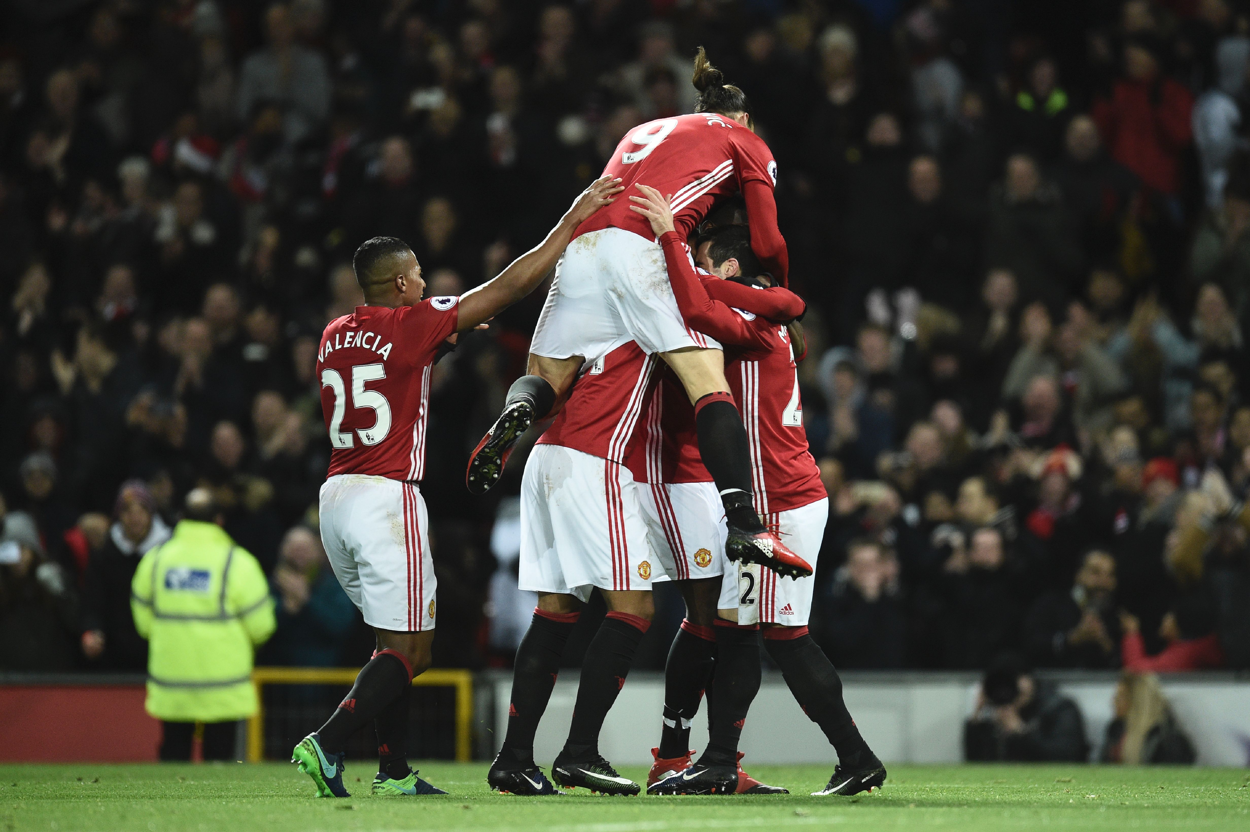 Manchester United's Swedish striker Zlatan Ibrahimovic (C) jumps into the celebration after Manchester United's Armenian midfielder Henrikh Mkhitaryan scored their third goal during the English Premier League football match between Manchester United and Sunderland at Old Trafford in Manchester, north west England, on December 26, 2016. / AFP / Oli SCARFF / RESTRICTED TO EDITORIAL USE. No use with unauthorized audio, video, data, fixture lists, club/league logos or 'live' services. Online in-match use limited to 75 images, no video emulation. No use in betting, games or single club/league/player publications.  /         (Photo credit should read OLI SCARFF/AFP/Getty Images)