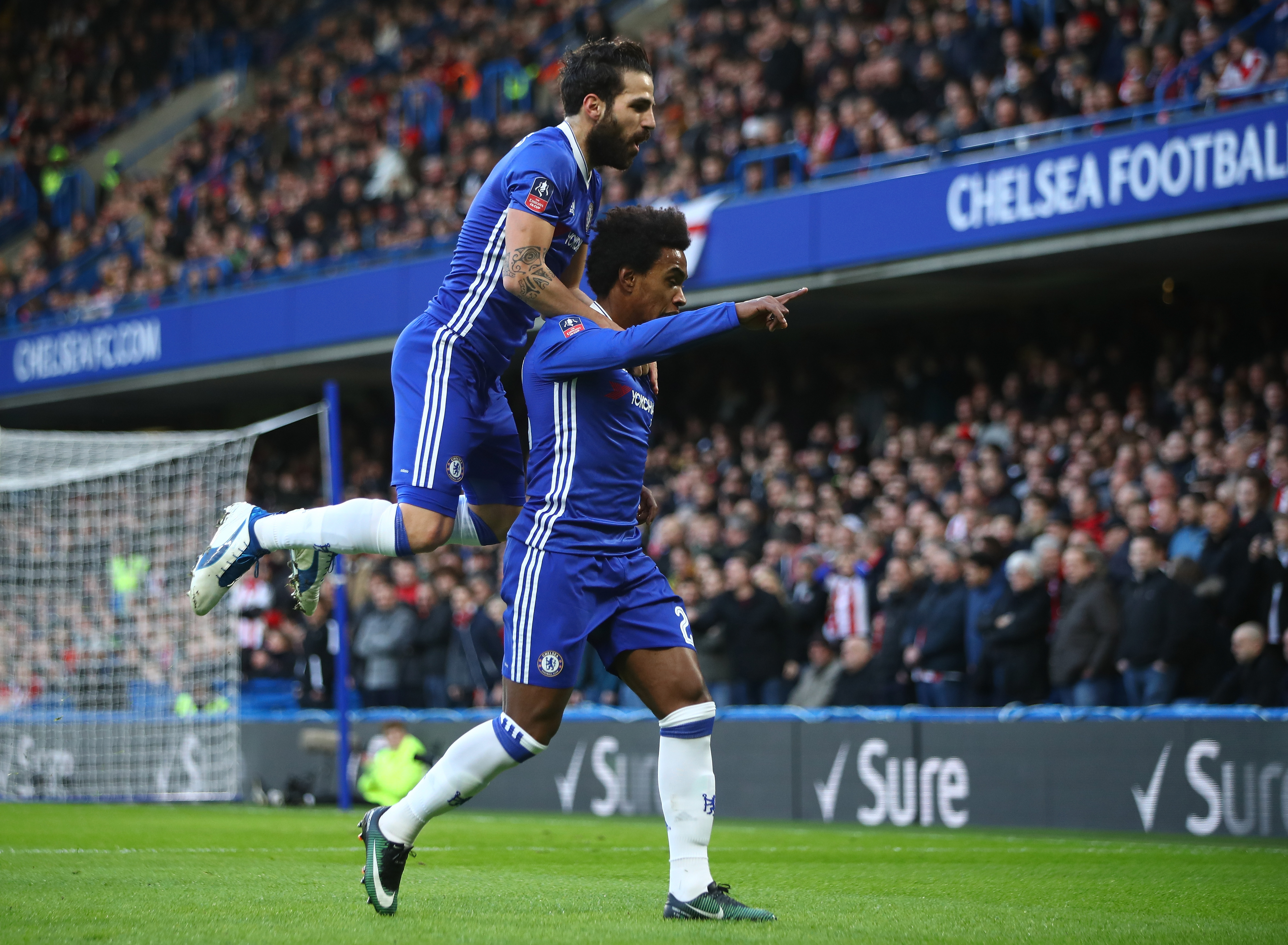 LONDON, ENGLAND - JANUARY 28:  Willian (R) of Chelsea celebrates scoring the opening goal with his team mate Cesc Fabregas (L) during the Emirates FA Cup Fourth Round match between Chelsea and Brentford at Stamford Bridge on January 28, 2017 in London, England.  (Photo by Clive Mason/Getty Images)