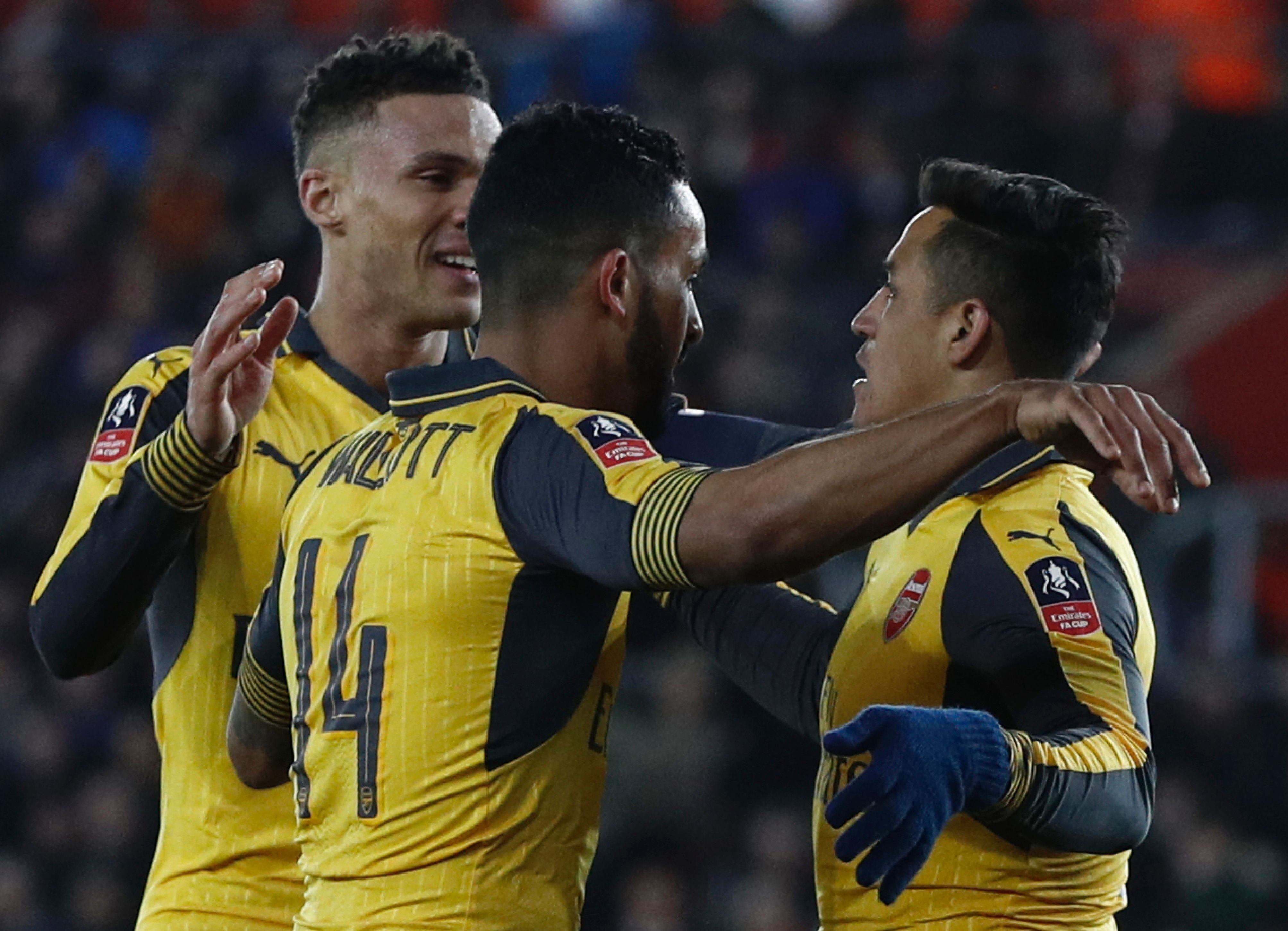 Arsenal's English midfielder Theo Walcott (C) celebrates scoring his team's fourth goal with Arsenal's Chilean striker Alexis Sanchez (R) during the English FA Cup fourth round football match between Southampton and Arsenal at St Mary's in Southampton, southern England on January 28, 2017. / AFP / Adrian DENNIS / RESTRICTED TO EDITORIAL USE. No use with unauthorized audio, video, data, fixture lists, club/league logos or 'live' services. Online in-match use limited to 75 images, no video emulation. No use in betting, games or single club/league/player publications.  /         (Photo credit should read ADRIAN DENNIS/AFP/Getty Images)