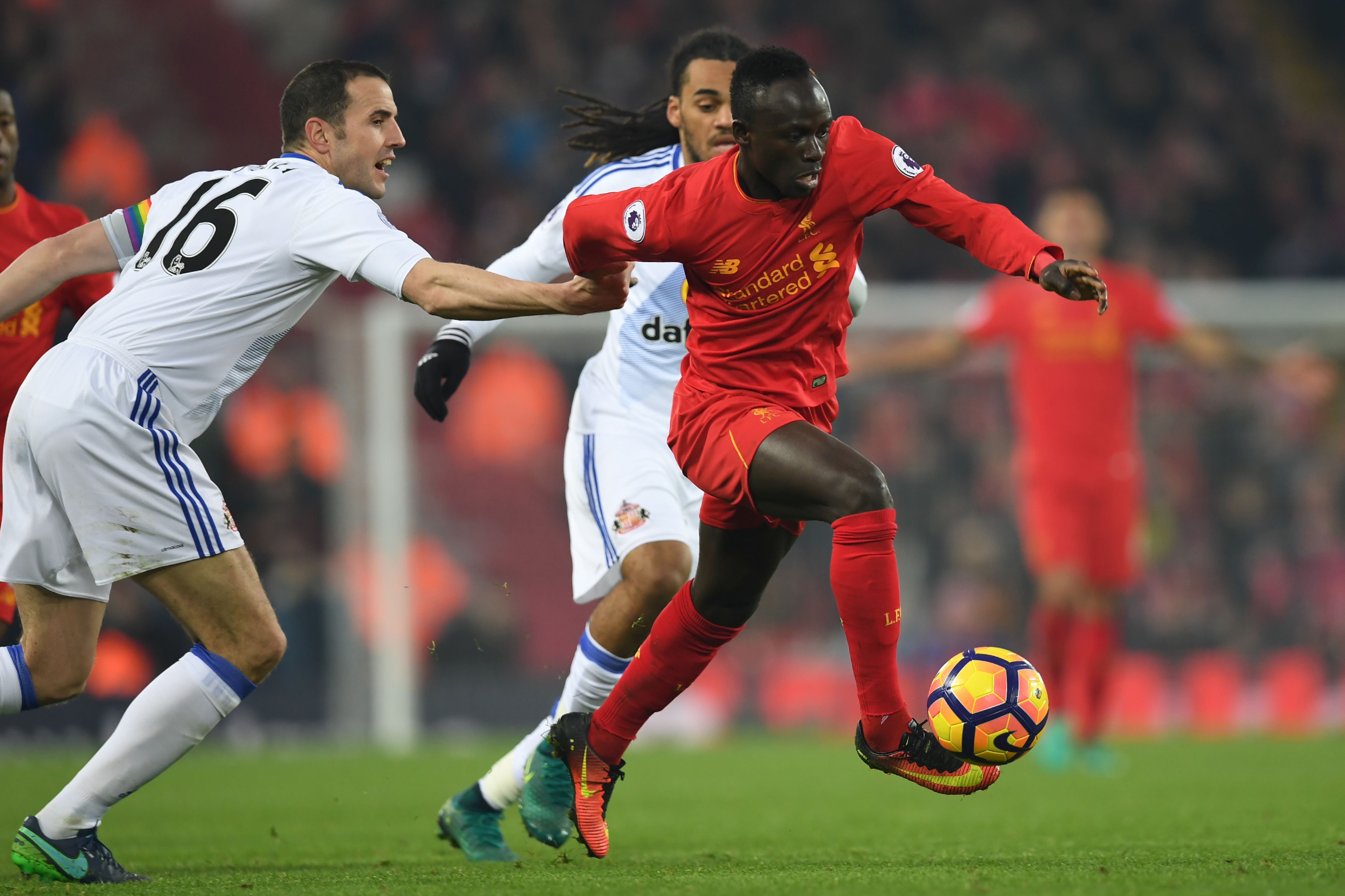 Liverpool's Senegalese midfielder Sadio Mane (R) tries to dribble away from Sunderland's Irish defender John O'Shea (L) during the English Premier League football match between Liverpool and Sunderland at Anfield in Liverpool, north west England on November 26, 2016. / AFP / Paul ELLIS / RESTRICTED TO EDITORIAL USE. No use with unauthorized audio, video, data, fixture lists, club/league logos or 'live' services. Online in-match use limited to 75 images, no video emulation. No use in betting, games or single club/league/player publications.  /         (Photo credit should read PAUL ELLIS/AFP/Getty Images)