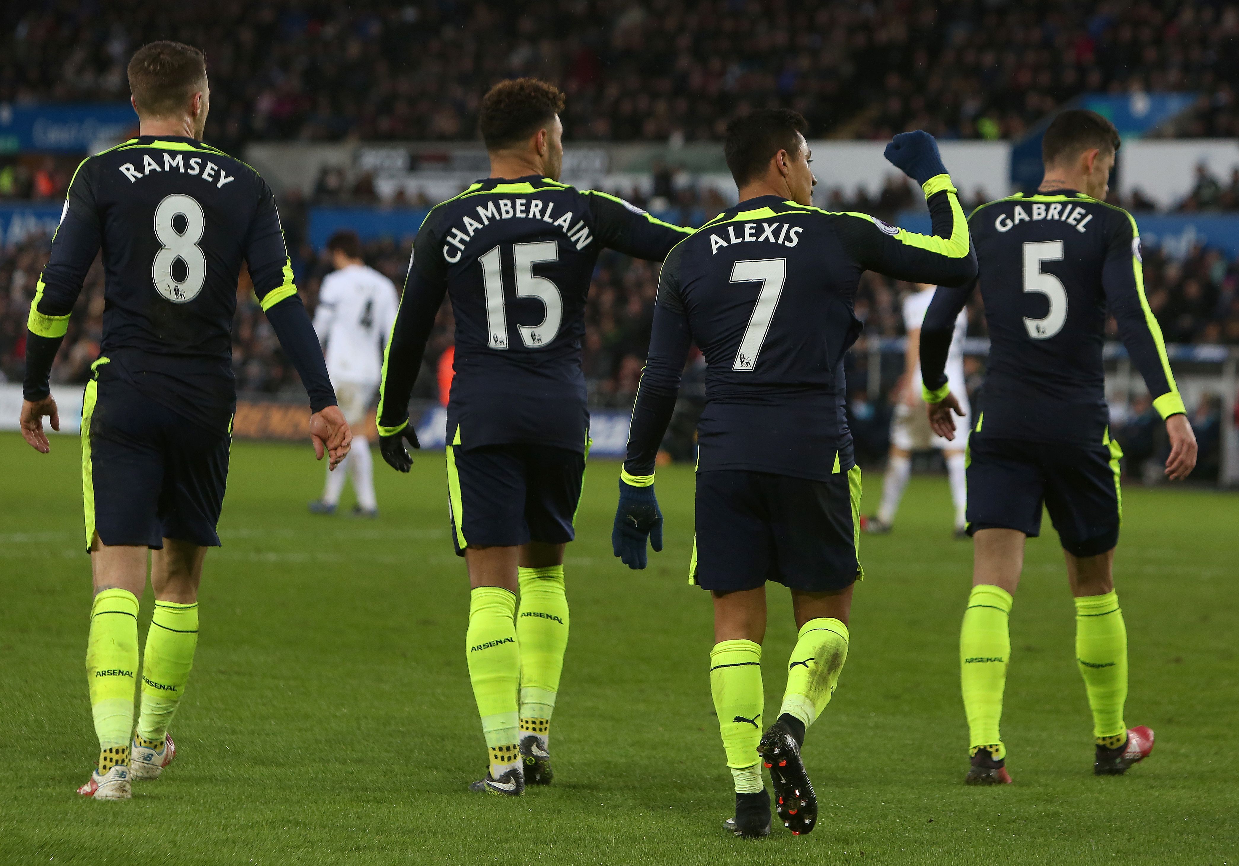 Arsenal's Chilean striker Alexis Sanchez (2R) celebrates scoring his team's fourth goal during the English Premier League football match between Swansea City and Arsenal at The Liberty Stadium in Swansea, south Wales on January 14, 2017. / AFP / Geoff CADDICK / RESTRICTED TO EDITORIAL USE. No use with unauthorized audio, video, data, fixture lists, club/league logos or 'live' services. Online in-match use limited to 75 images, no video emulation. No use in betting, games or single club/league/player publications.  /         (Photo credit should read GEOFF CADDICK/AFP/Getty Images)