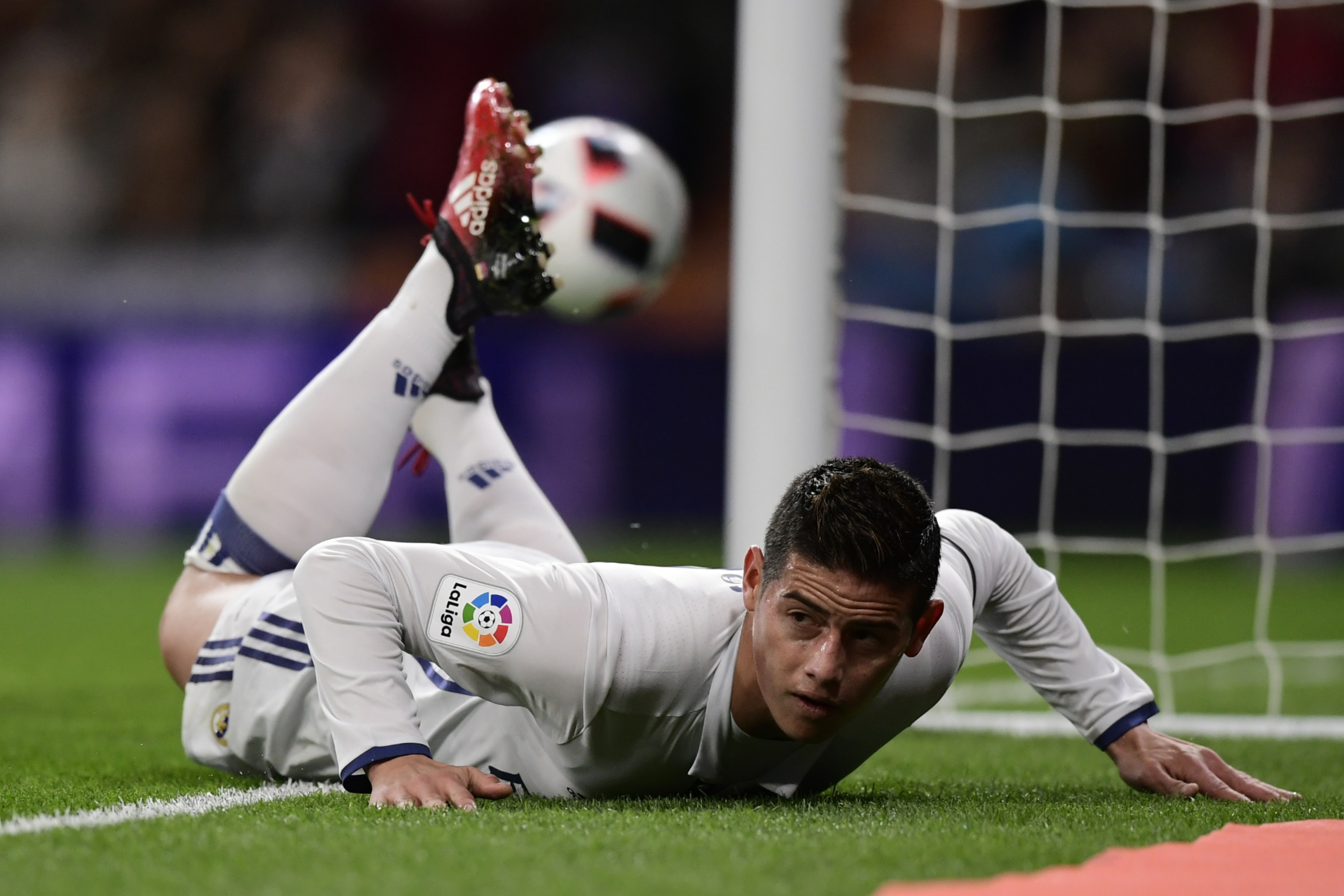 Real Madrid's Colombian midfielder James Rodriguez lies on the ground as he celebrates after scoring during the Spanish Copa del Rey (King's Cup) Round of 32 second leg football match Real Madrid CF vs Cultural y Deportiva Leonesa at the Santiago Bernabeu stadium in Madrid on November 30, 2016. (Photo by Javier Soriano/AFP/Getty Images)