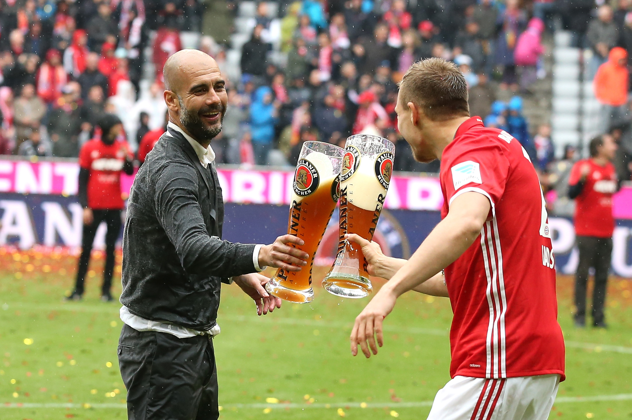 MUNICH, GERMANY - MAY 14: Josep Guardiola, head coach of Bayern Muenchen and Holger Badstuber of Bayern Muenchen celebrate with beer during the Bundesliga match between FC Bayern Muenchen and Hannover 96 at Allianz Arena on May 14, 2016 in Munich, Germany.  (Photo by Lars Baron/Bongarts/Getty Images)