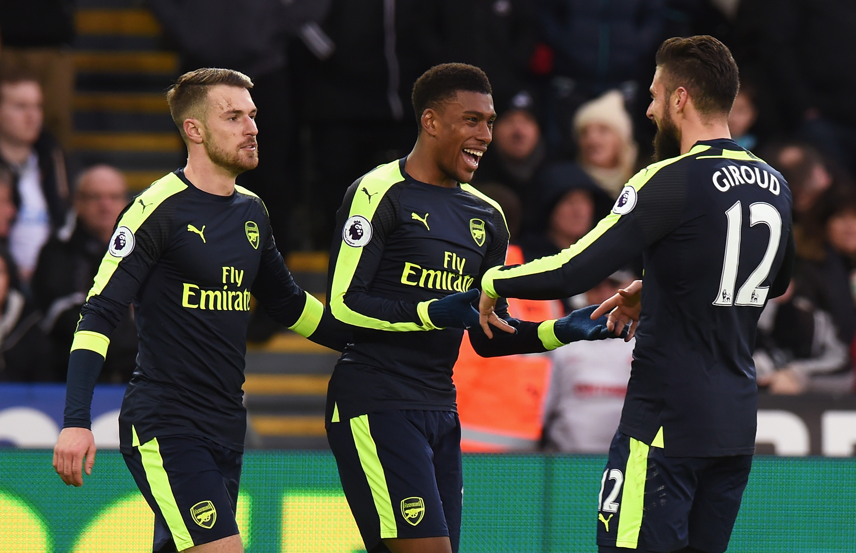 SWANSEA, WALES - JANUARY 14:  Aaron Ramsey of Arsenal (L), Alex Iwobi of Arsenal (C) and Olivier Giroud of Arsenal (R) celebrate their second goal as Jack Cork of Swansea City (not seen) scores a own goal during the Premier League match between Swansea City and Arsenal at Liberty Stadium on January 14, 2017 in Swansea, Wales.  (Photo by Tony Marshall/Getty Images)