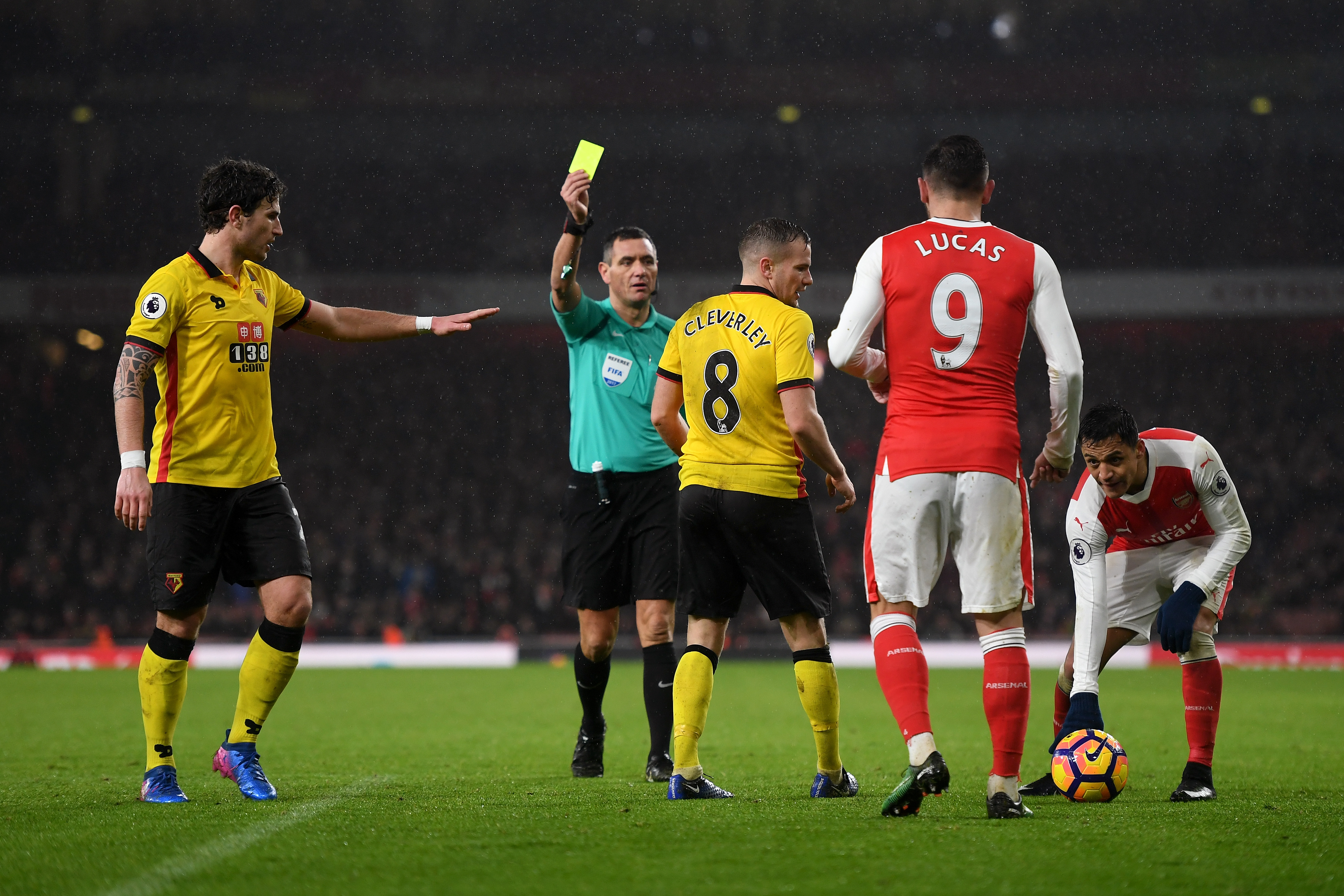 LONDON, ENGLAND - JANUARY 31:  Tom Cleverley (C) of Watford is shown a yellow card referee Andre Marriner(2nd L)  during the Premier League match between Arsenal and Watford at Emirates Stadium on January 31, 2017 in London, England.  (Photo by Mike Hewitt/Getty Images)