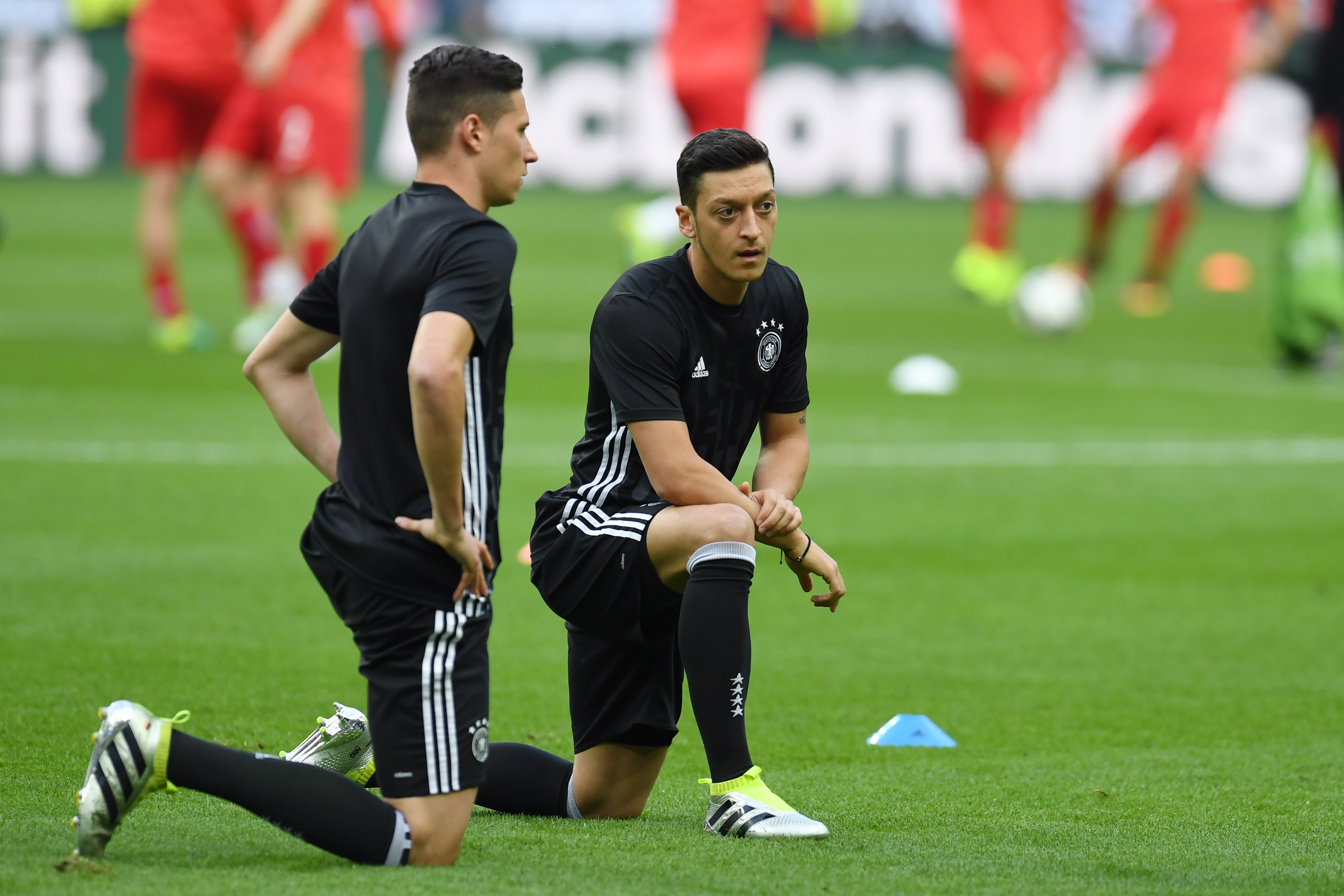 Germany's midfielder Julian Draxler (L) and Germany's midfielder Mesut Oezil warm-up ahead of the Euro 2016 group C football match between Germany and Poland at the Stade de France stadium in Saint-Denis near Paris on June 16, 2016. / AFP / PATRIK STOLLARZ        (Photo credit should read PATRIK STOLLARZ/AFP/Getty Images)